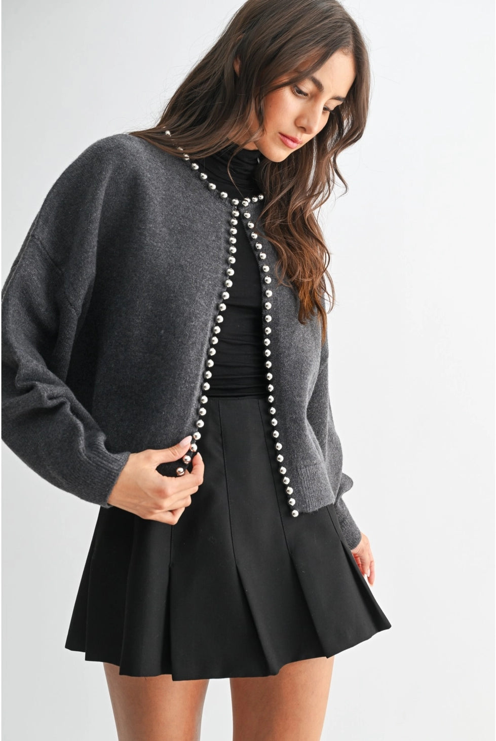 The Celeste Cardigan in a soft knit fabric, featuring delicate pearl detailing, a button-front design, and an elegant feminine silhouette.