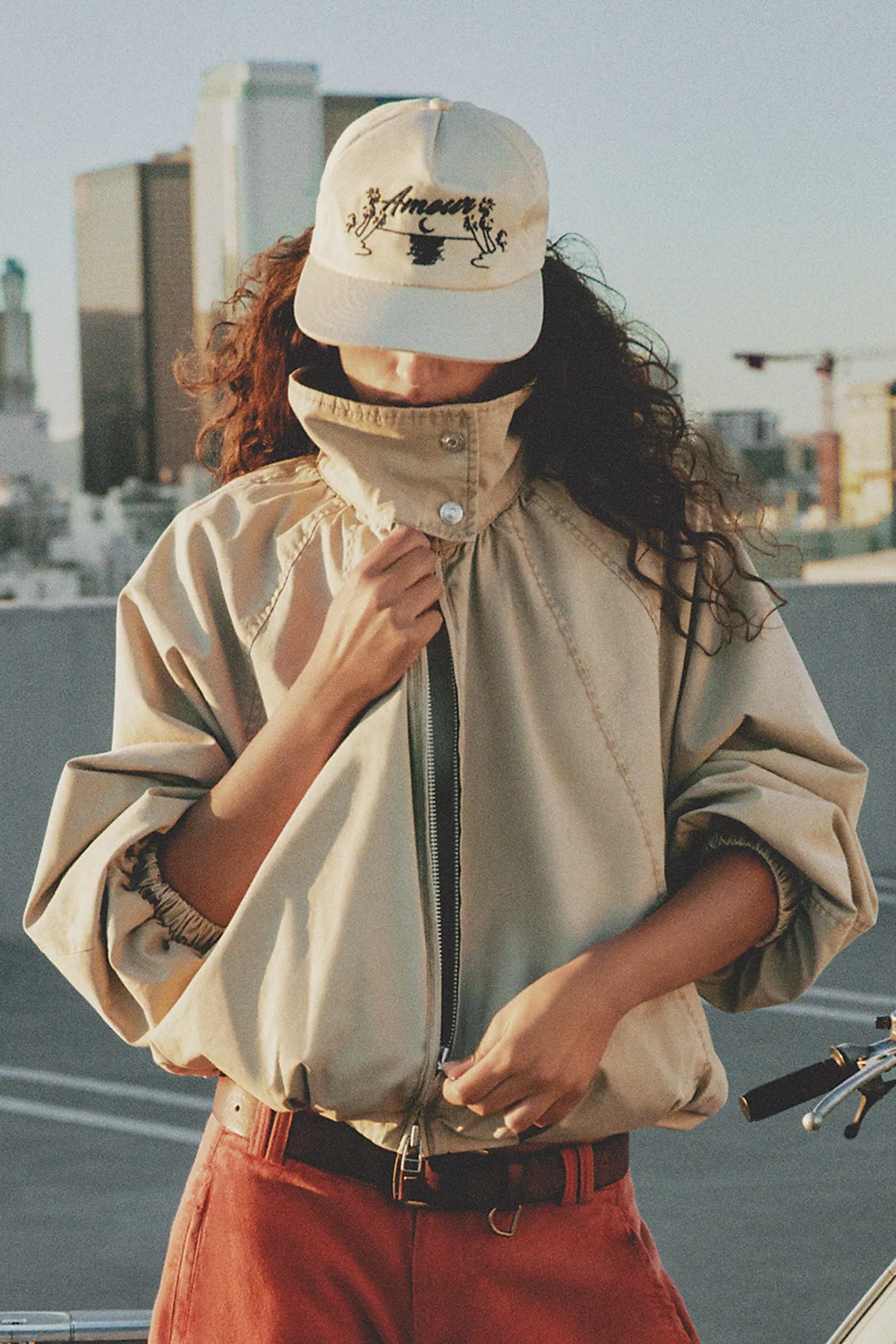Free People Chelsea Funnel Neck Jacket in Oatmeal featuring an oversized slouchy fit, lightweight cotton-blend fabric, funnel-neck collar, raglan sleeves, adjustable drawcord waist, front zipper closure, and side slit pockets.