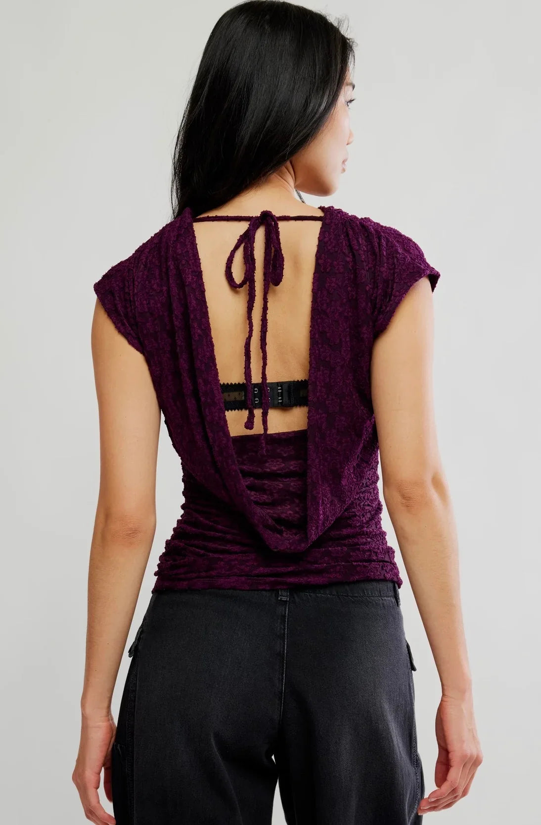 Italian plum short-sleeve top with a tonal floral texture, plunging cowl neckline, relaxed draped silhouette, and adjustable tie-back detail.