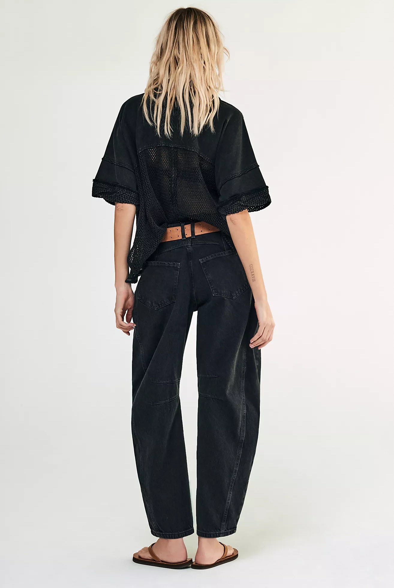 woman wearing washed black mid rise barrel jeans in an ankle length