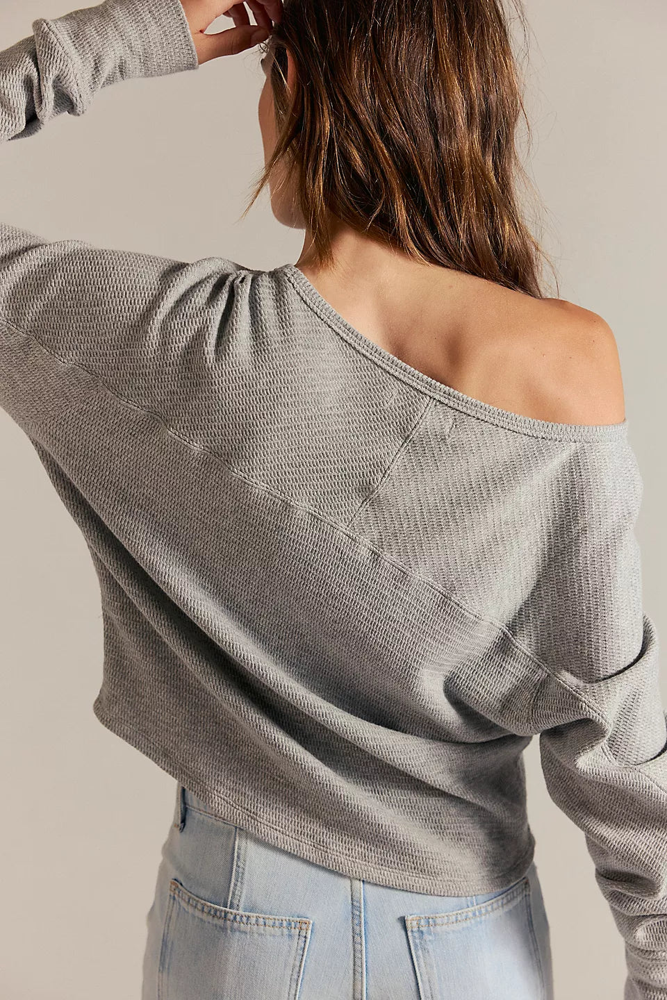 Women's textured thermal long sleeve top with a boat neckline, relaxed dolman sleeves, exposed seam detailing, and elongated cuffs. heather grey.