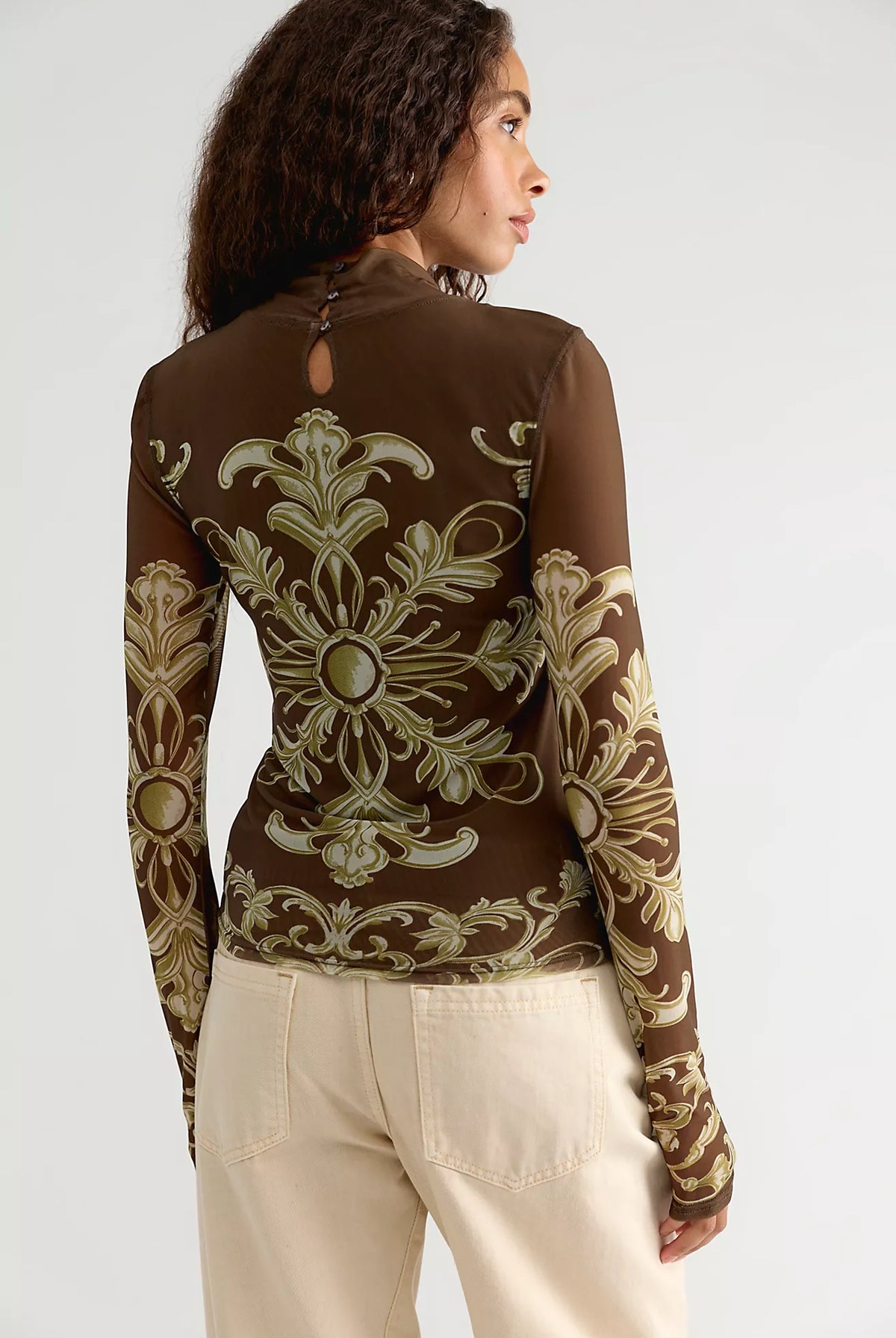 Free People Jessa Long Sleeve Top in Olive Combo featuring a fitted silhouette, semi-sheer mesh fabric, high turtleneck, long sleeves, intricate olive and cream ornamental print, and keyhole detail at the back.