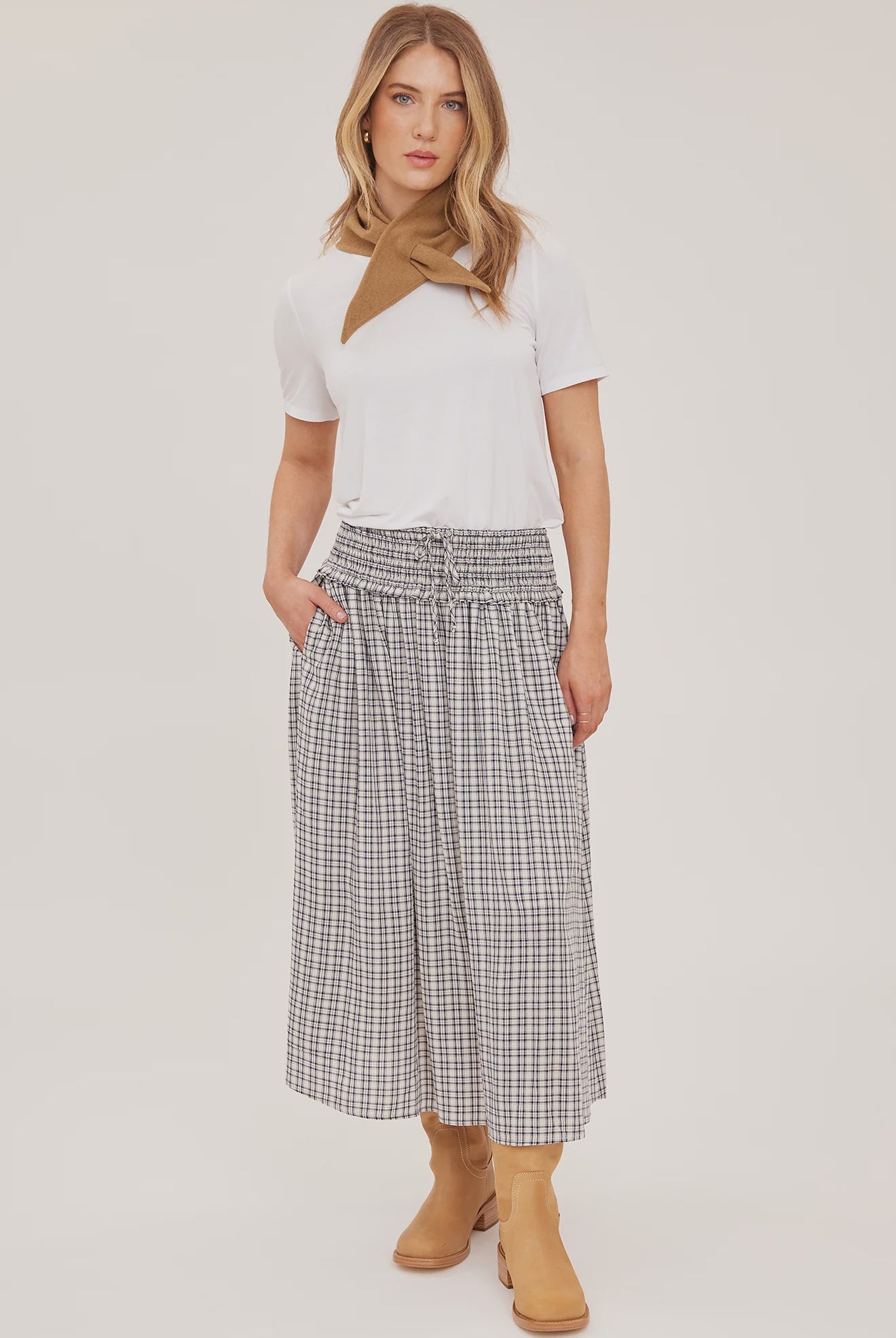 Women's black maxi skirt in a lightweight mini check fabric featuring a smocked high-rise waistband, flowing silhouette, inseam pockets, and a partially lined design