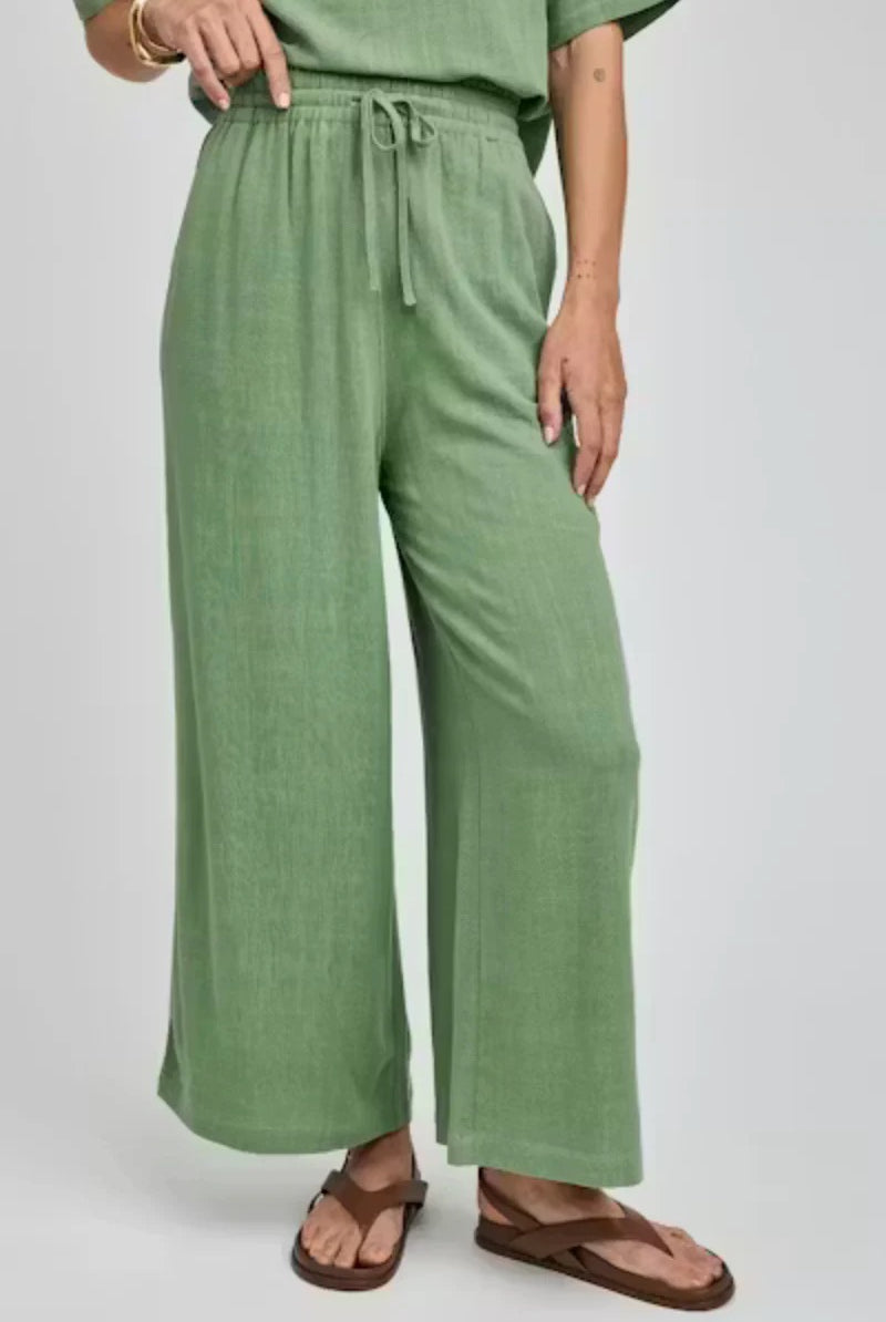 Person wearing green wide-leg pants on a white background