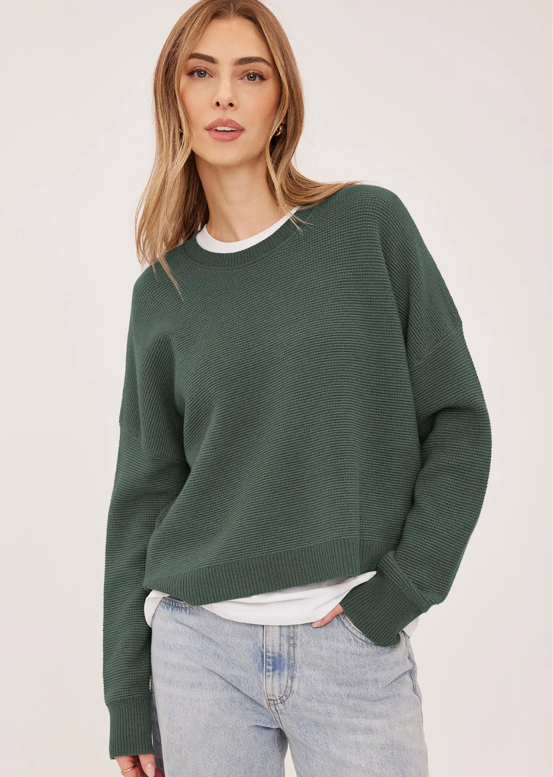 Axel oversized sweater in a soft waffle-knit yarn, featuring a crew neckline, exposed seam details, and side slits for a relaxed, textured look.