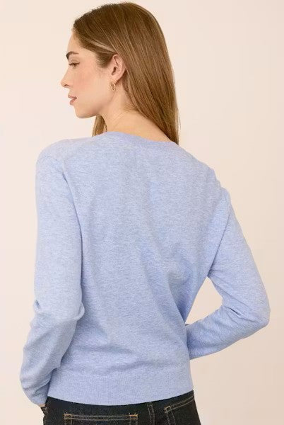 Woman wearing the Gentle Fawn Carina Sweater in Heather Blue, featuring a regular fit with a soft, lightweight knit in a classic light blue shade.