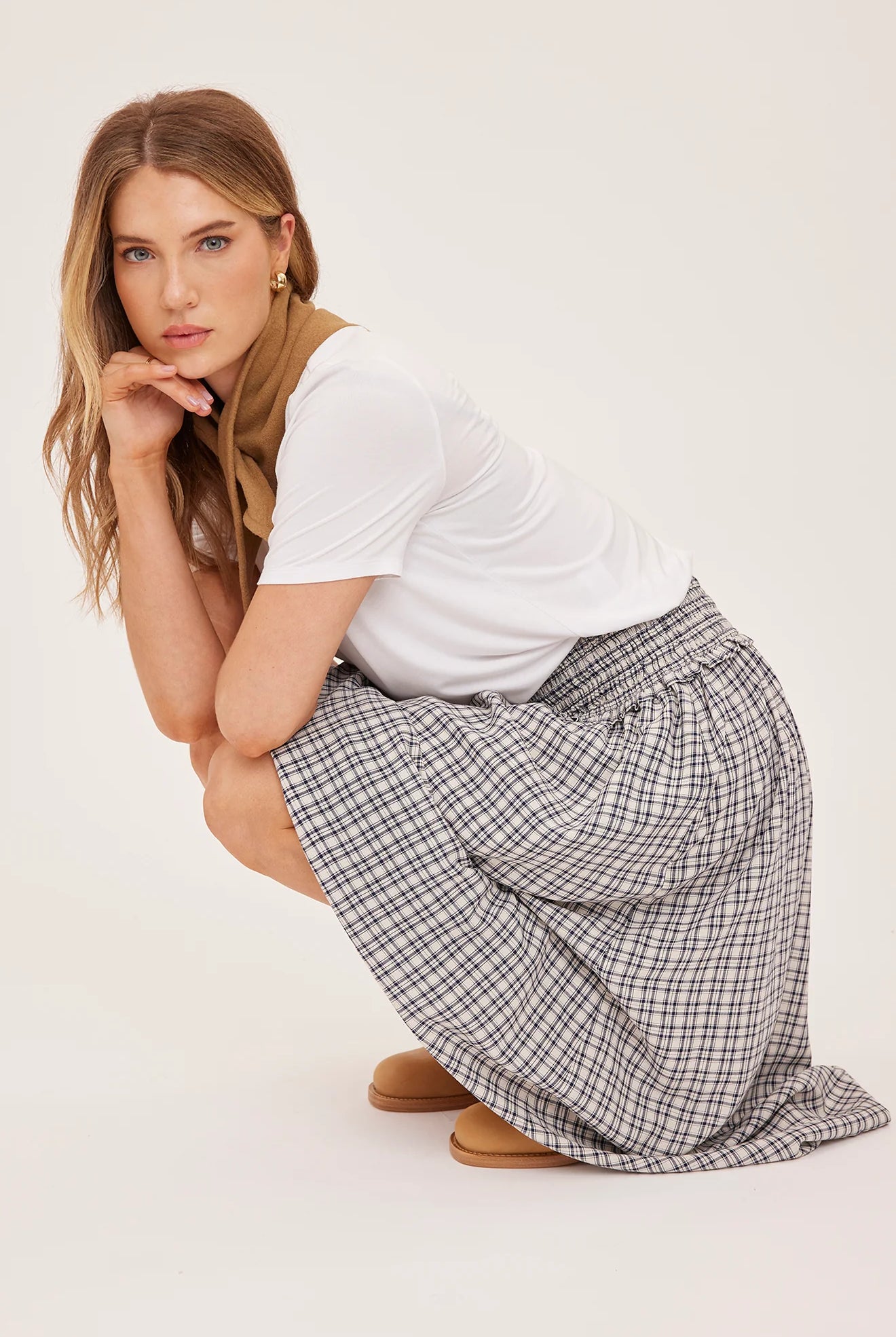 Women's black maxi skirt in a lightweight mini check fabric featuring a smocked high-rise waistband, flowing silhouette, inseam pockets, and a partially lined design