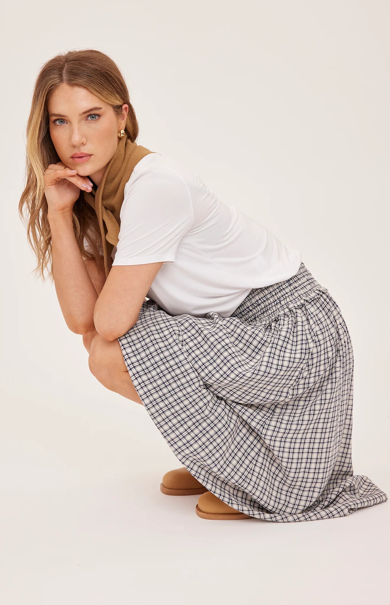 Women's black maxi skirt in a lightweight mini check fabric featuring a smocked high-rise waistband, flowing silhouette, inseam pockets, and a partially lined design