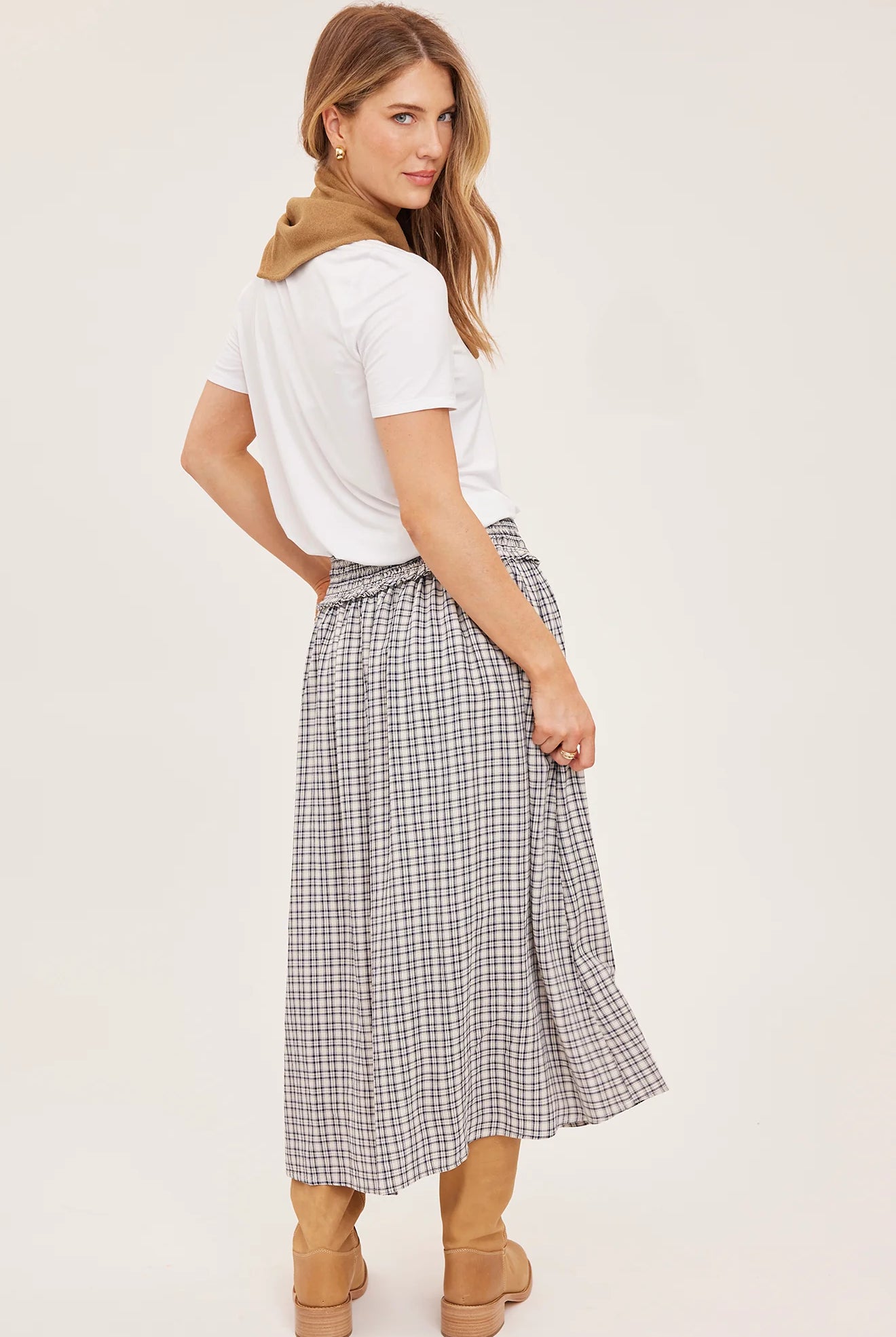 Women's black maxi skirt in a lightweight mini check fabric featuring a smocked high-rise waistband, flowing silhouette, inseam pockets, and a partially lined design