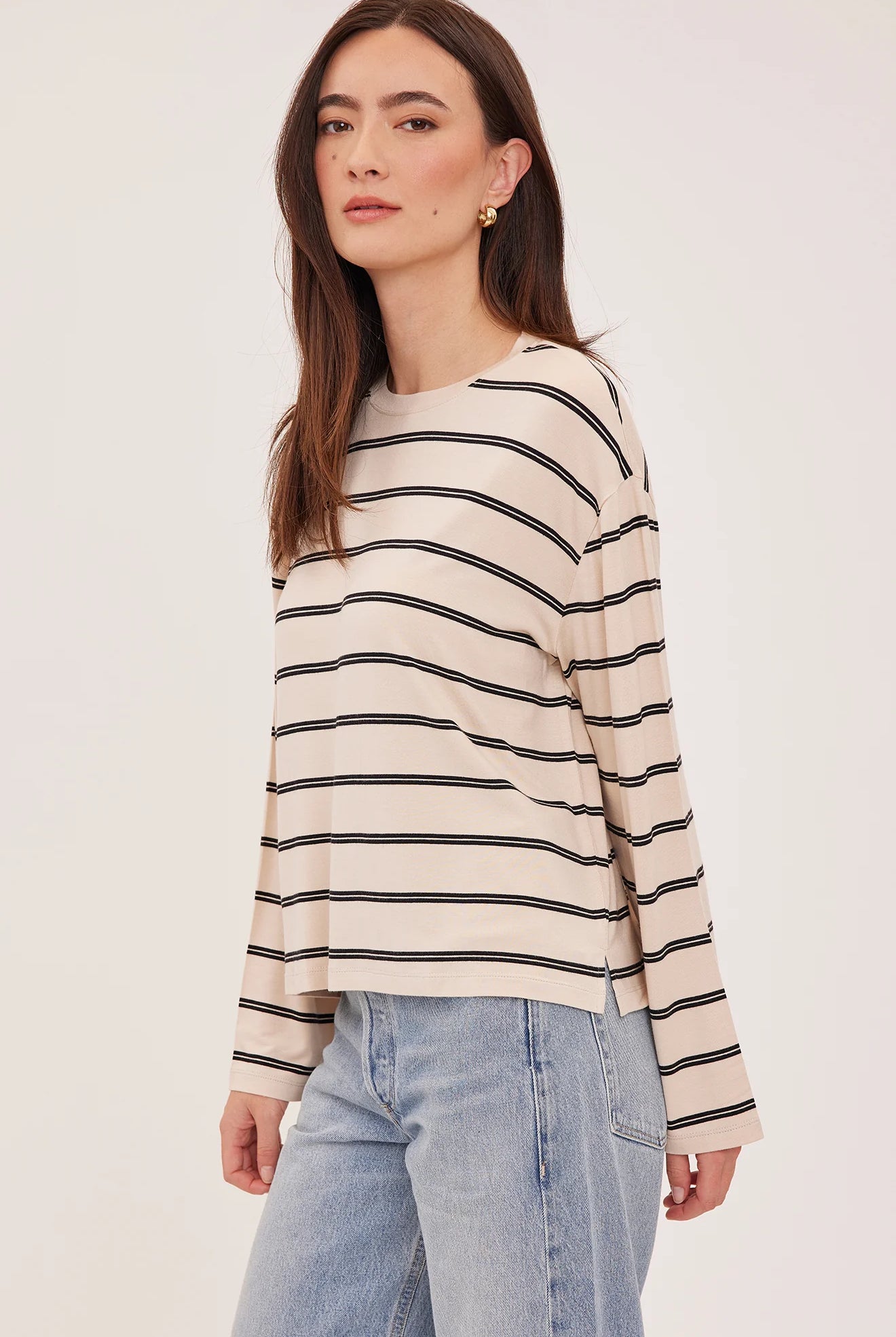Women's relaxed long sleeve top featuring cream and soft beige stripes, a classic crew neckline, side slits, and a lightweight rayon jersey knit.