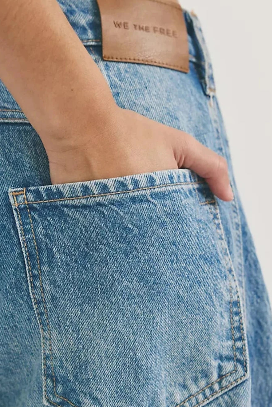 Close-up of blue jeans with a free people brand label