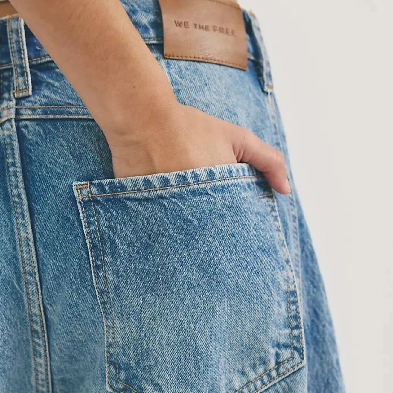 Close-up of blue jeans with a free people brand label