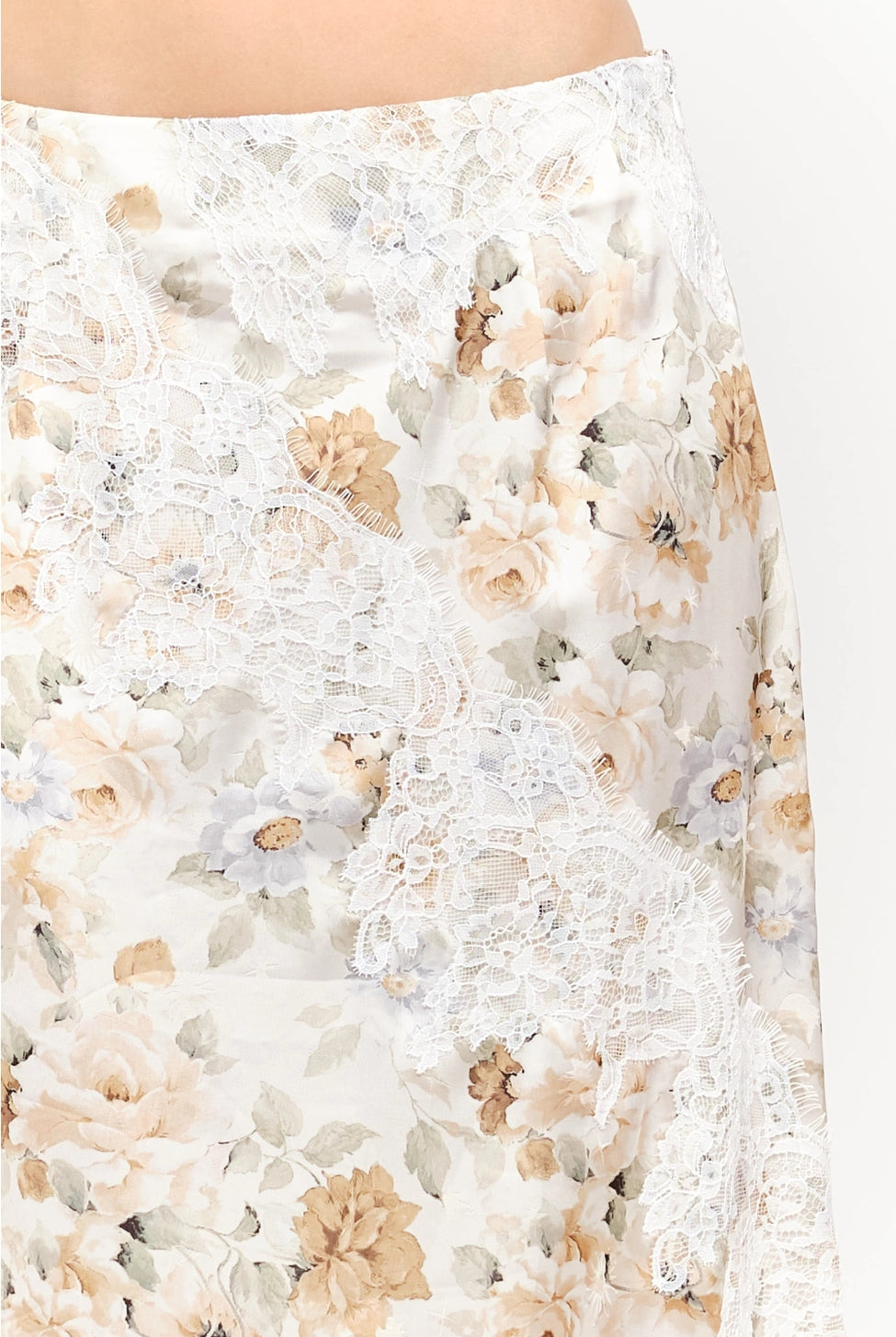 Harper Floral Midi Skirt in soft yellow and cream featuring a delicate floral print, smooth satin finish, white lace panel detailing, and a flowing midi-length silhouette.