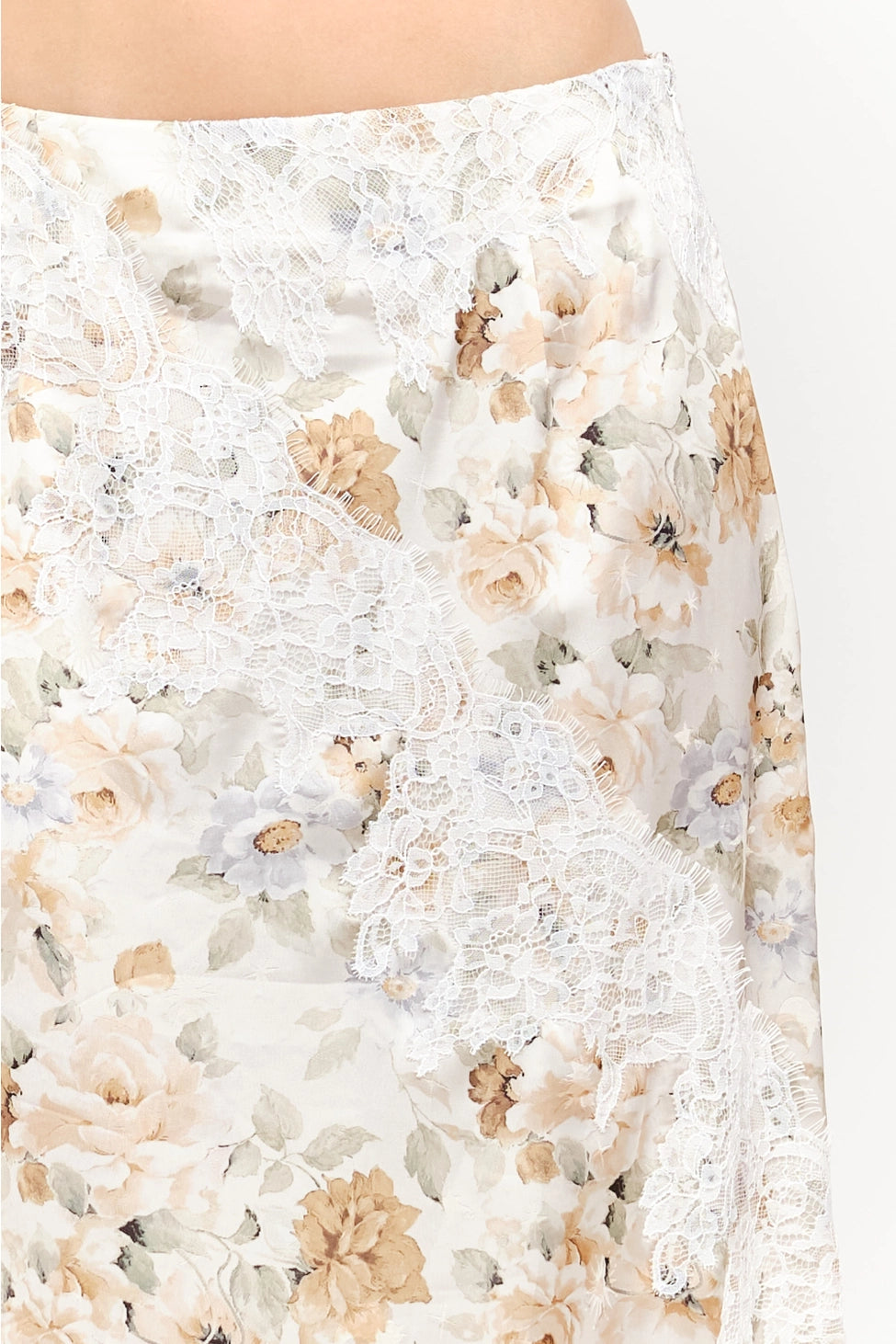 Harper Floral Midi Skirt in soft yellow and cream featuring a delicate floral print, smooth satin finish, white lace panel detailing, and a flowing midi-length silhouette.