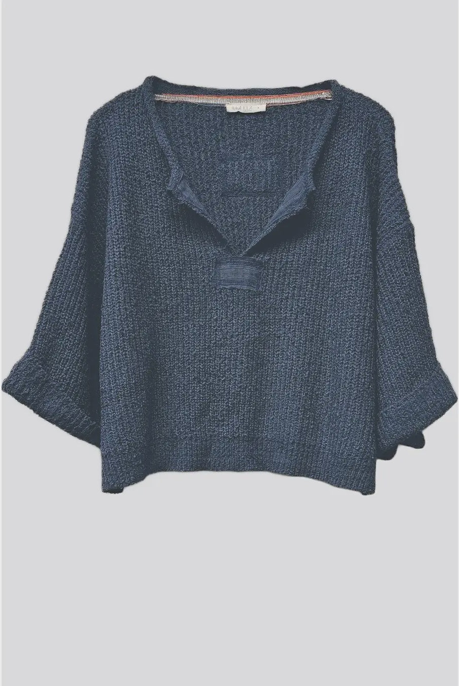 Lora chunky cropped sweater with a loose slouchy fit, V-neckline, relaxed ¾ sleeves, and contrasting solid patch details on the front and back.