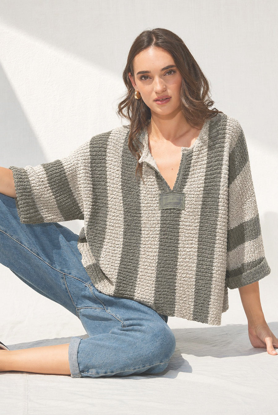 Loose, slouchy fit with a cropped length, V-neckline, 3/4 sleeves, vertical stripe design, and solid front and back patch detailing.
