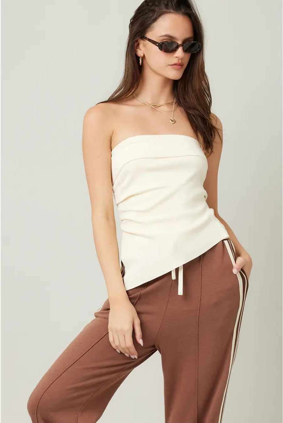 woman wearing a cream strapless asymmetrical top