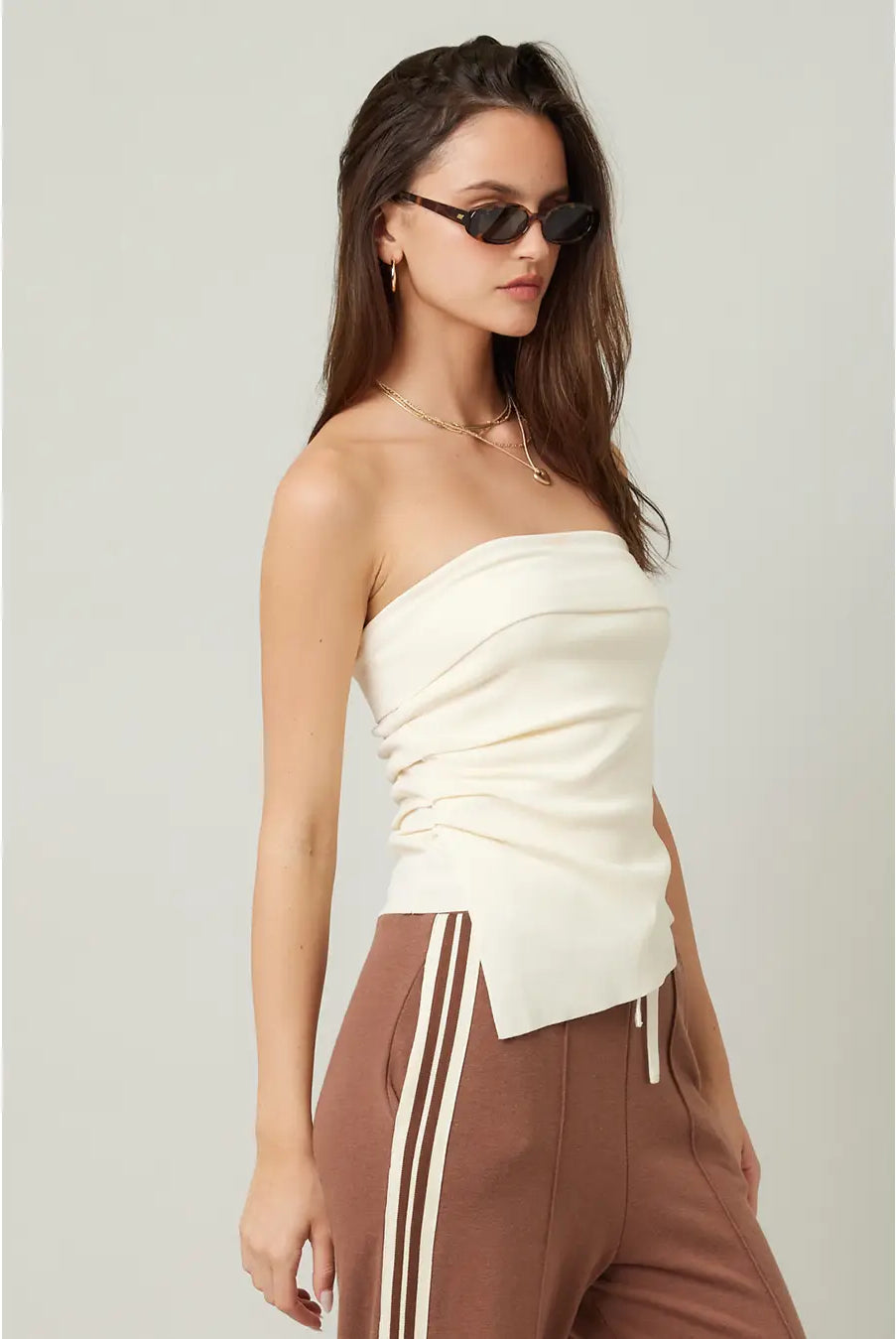 woman wearing a cream strapless asymmetrical top