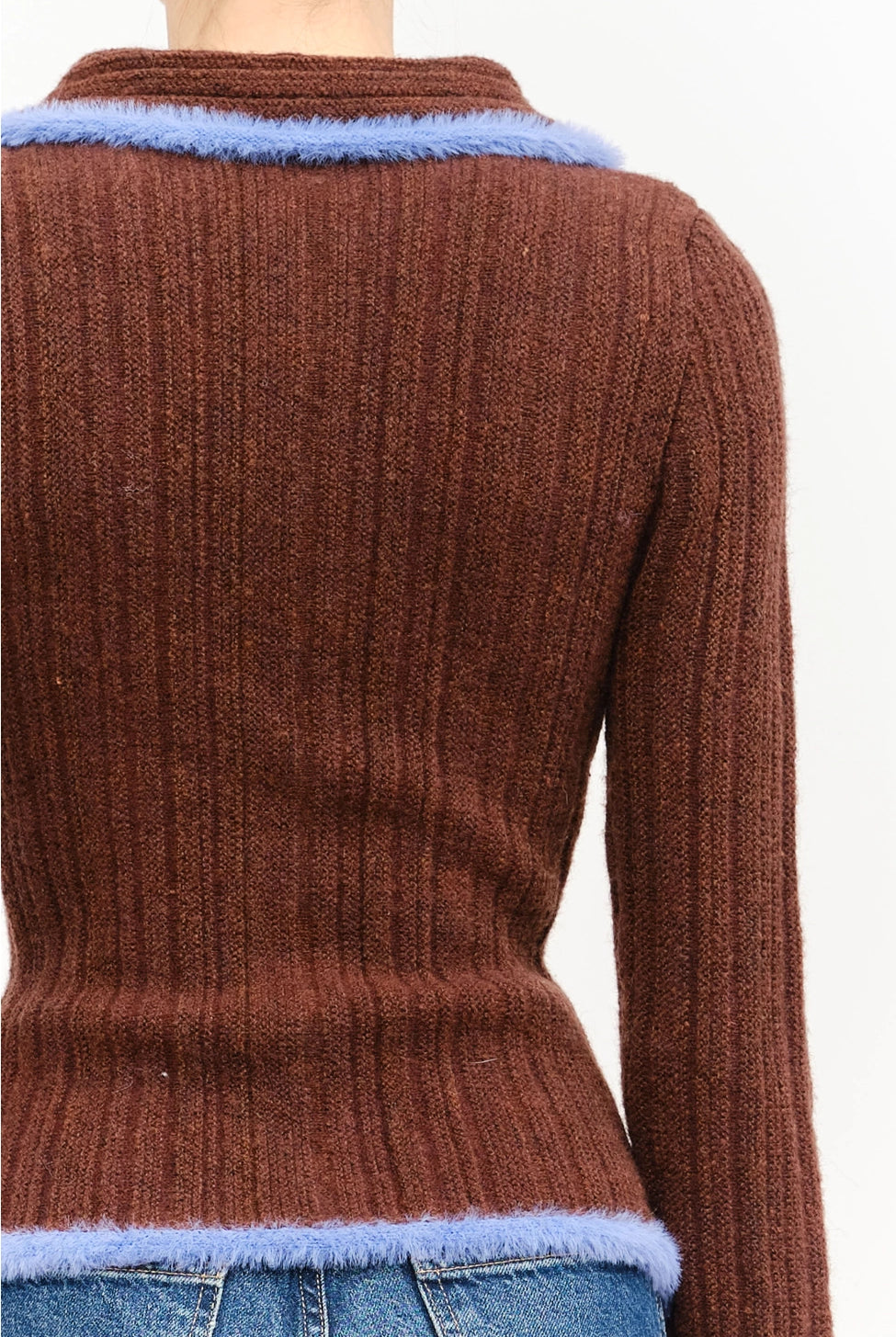 Model wearing the Jacquie Knit Top in brown, featuring a fitted silhouette, long sleeves, collared neckline, contrasting blue fuzzy trim, and two-way front zipper closure.