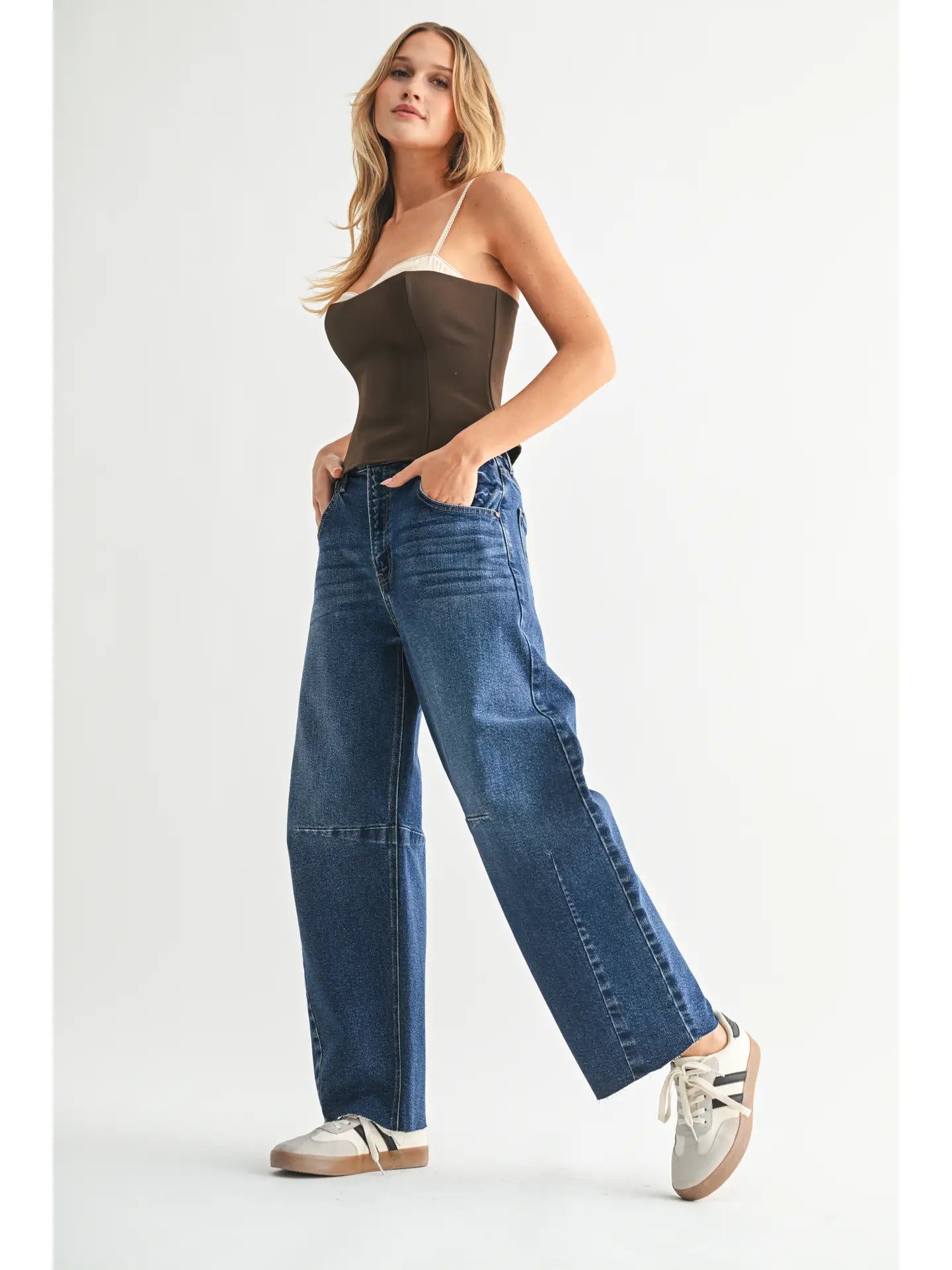 Dark denim barrel-leg jeans with an extra-wide silhouette, high rise, statement seam detailing, subtle whiskering, and silver hardware.