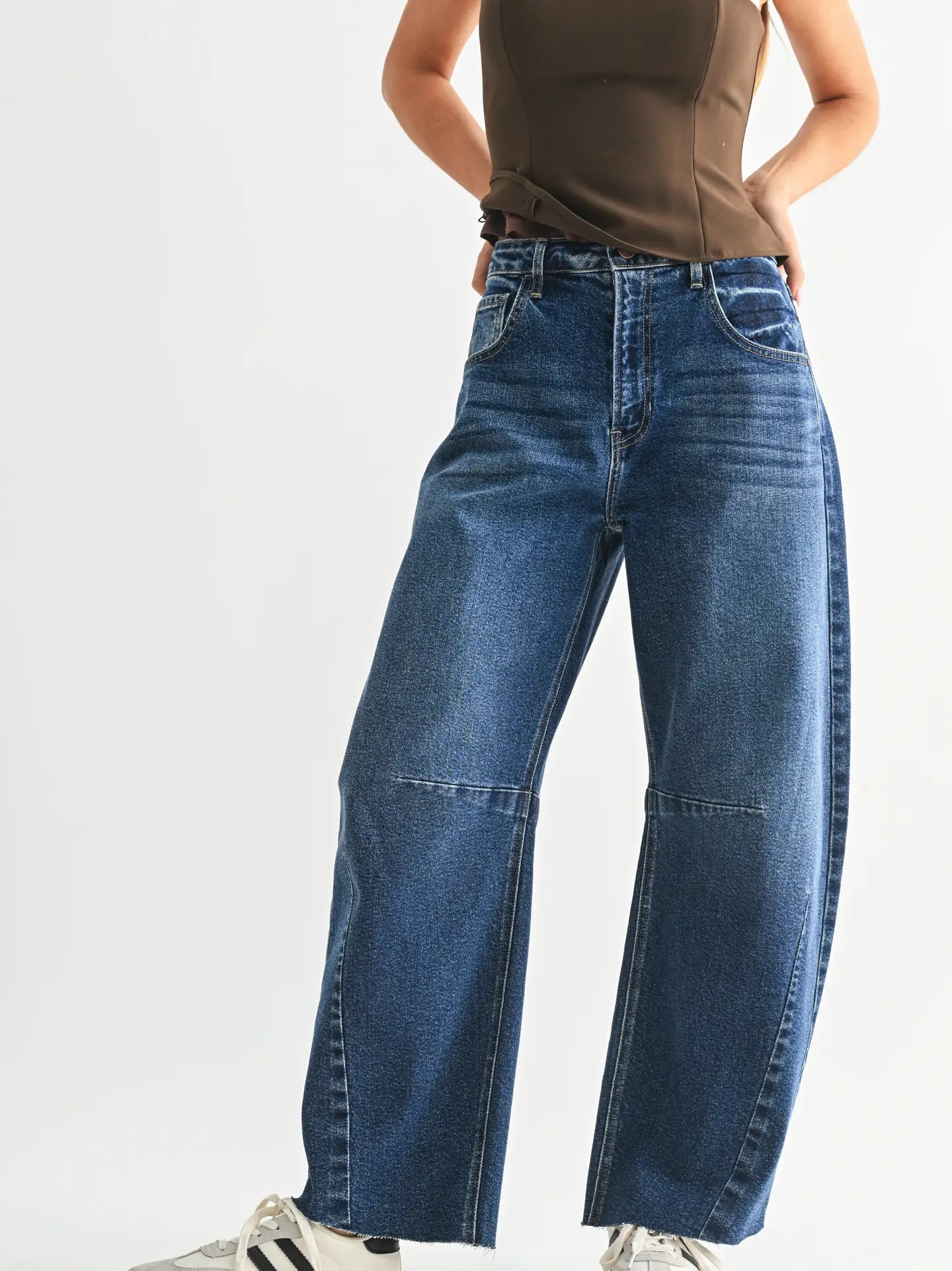 Dark denim barrel-leg jeans with an extra-wide silhouette, high rise, statement seam detailing, subtle whiskering, and silver hardware.