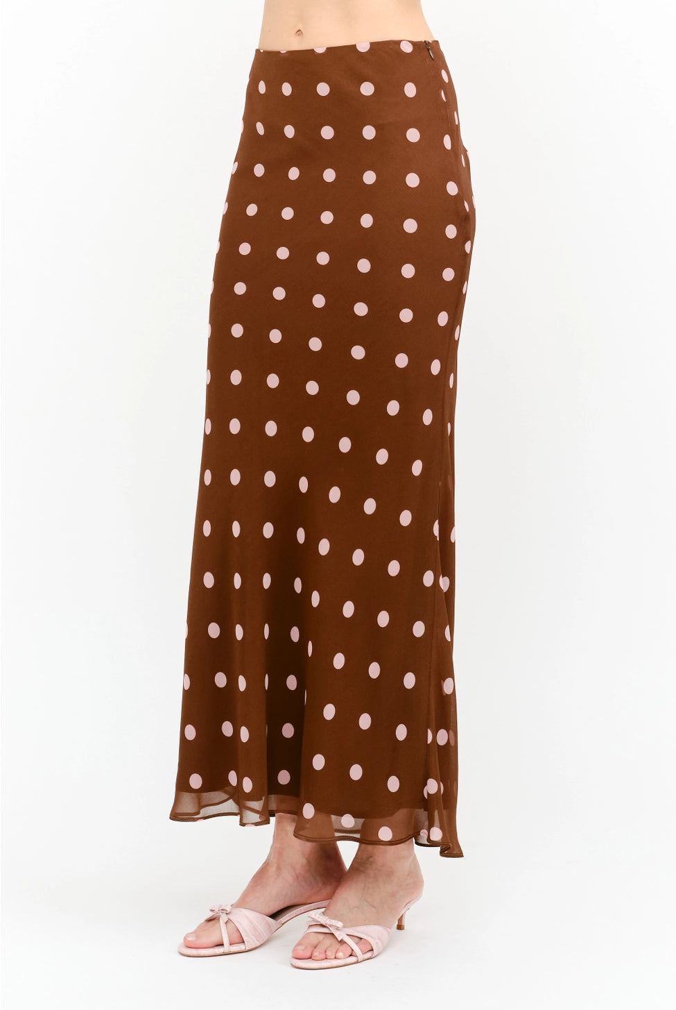 Kalila Midi Skirt in rich brown featuring soft pink polka dots, a flattering mermaid silhouette, and a flowing ankle-grazing hem.