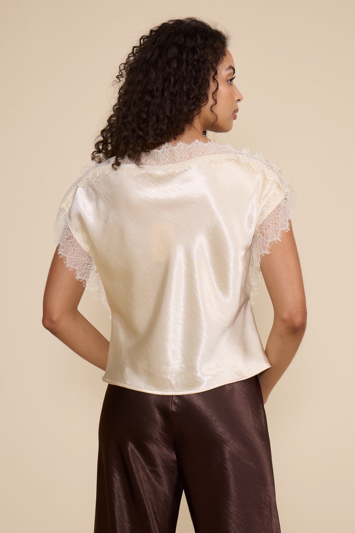 Lucy Paris Chris Lace Trim Top in ivory featuring a silky finish, relaxed fit, and delicate sheer lace trim along the neckline and short sleeves.