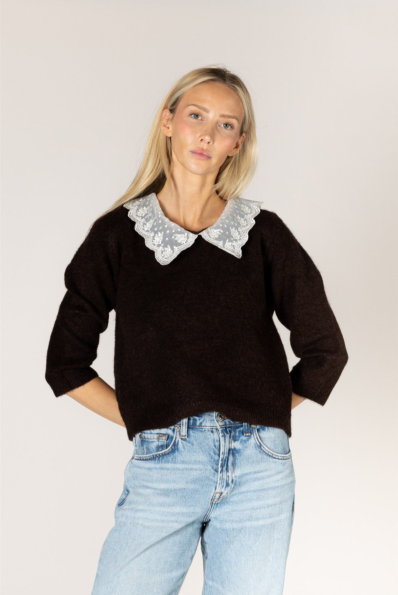 Knit sweater featuring a delicate lace collar, long sleeves, and a relaxed silhouette for a feminine, layered look.