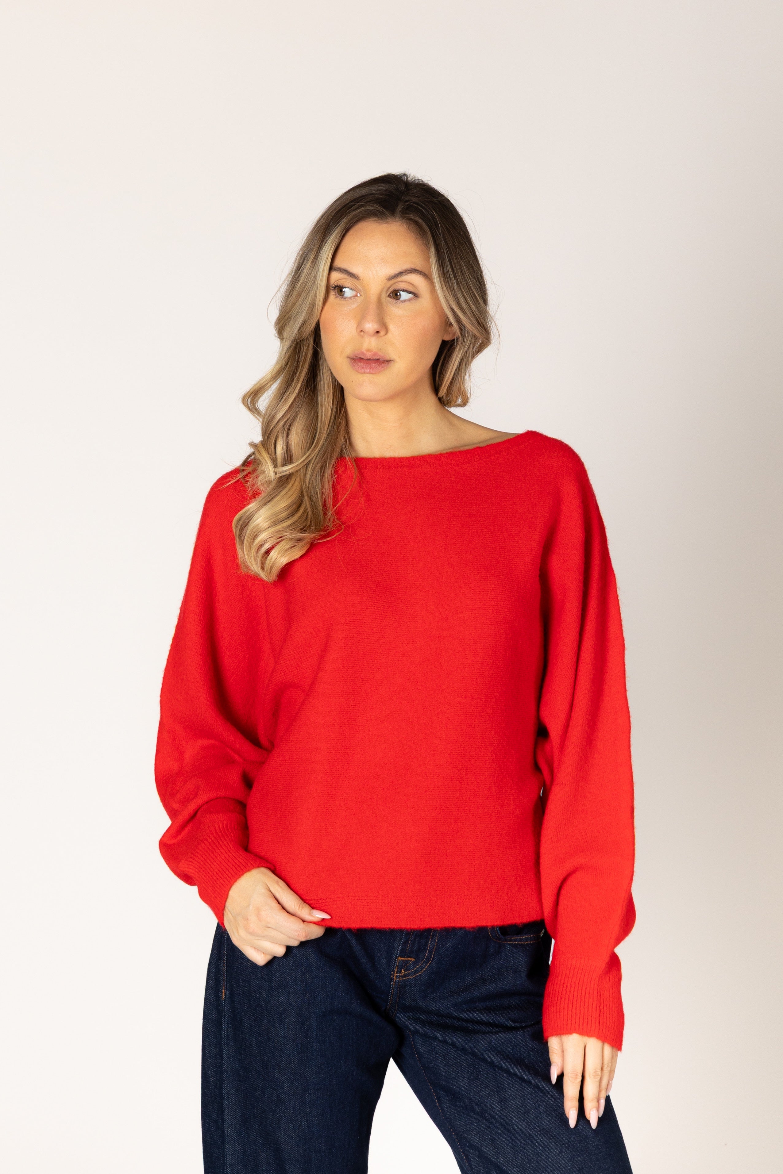 Off-the-shoulder knit sweater in a neutral tone, featuring a relaxed silhouette and wide neckline for an elegant, effortless look.