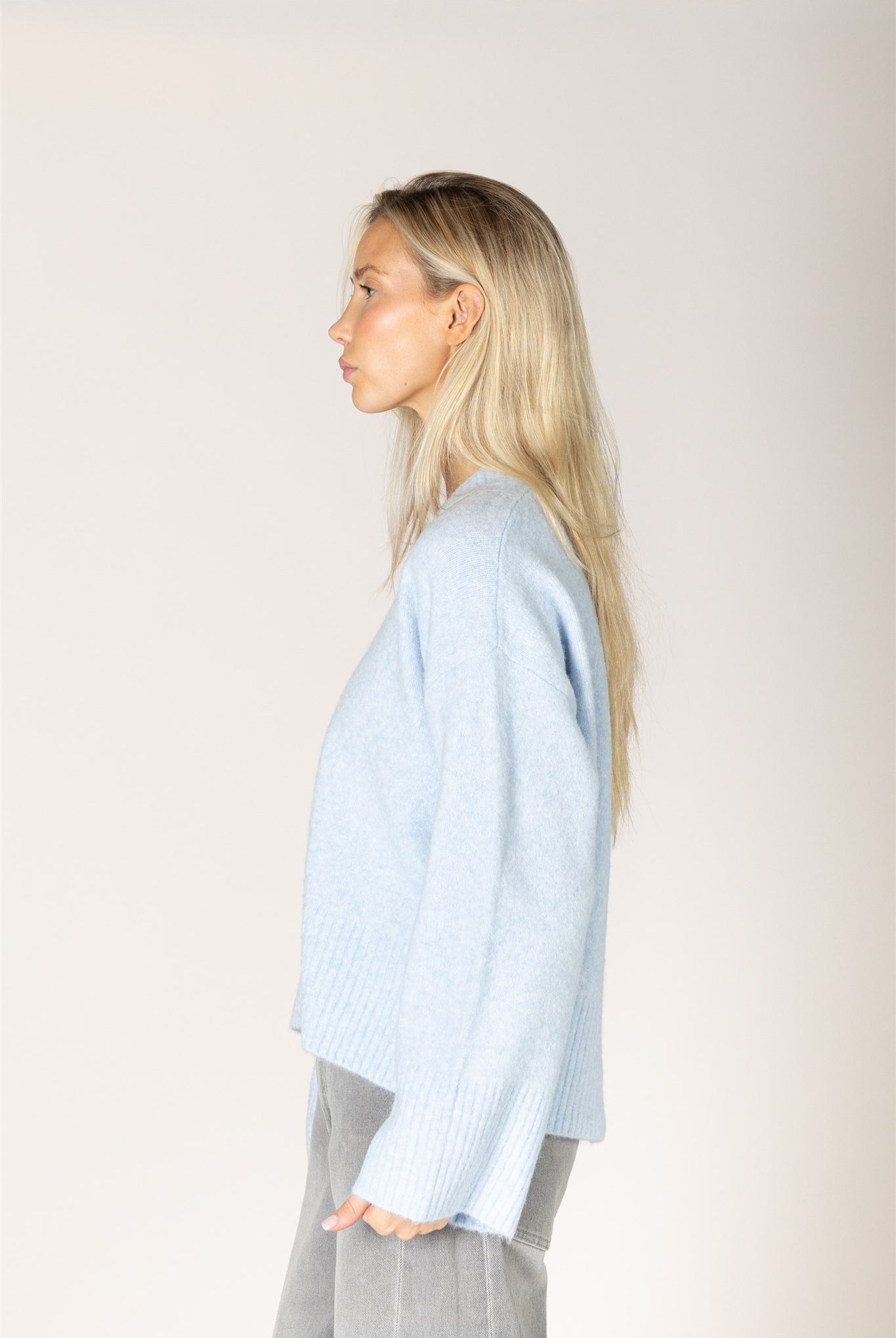 Breeze blue V-neck sweater in a lightweight knit, featuring a relaxed fit, long sleeves, and ribbed trim at the neckline, cuffs, and hem.