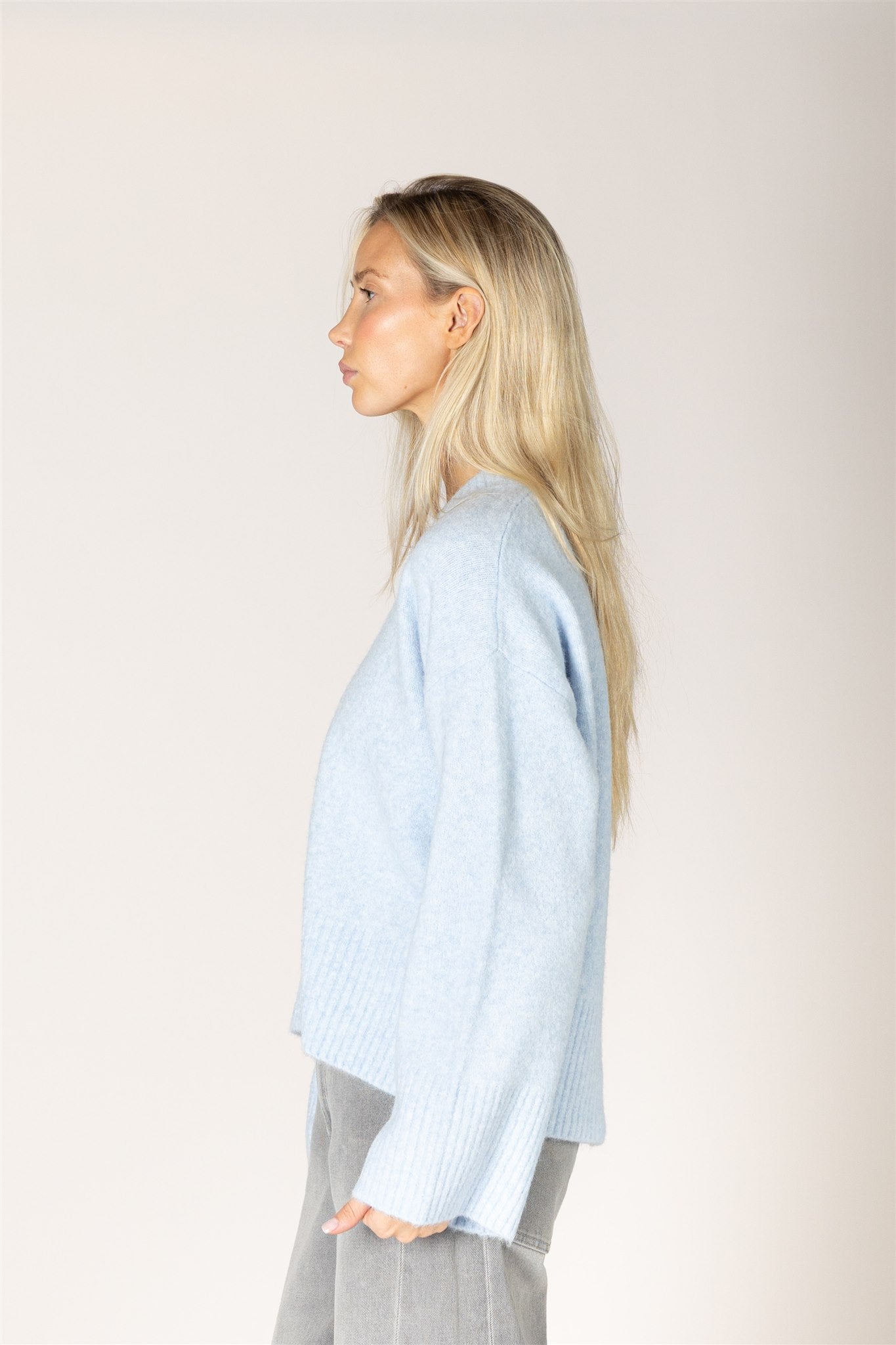 Breeze blue V-neck sweater in a lightweight knit, featuring a relaxed fit, long sleeves, and ribbed trim at the neckline, cuffs, and hem.