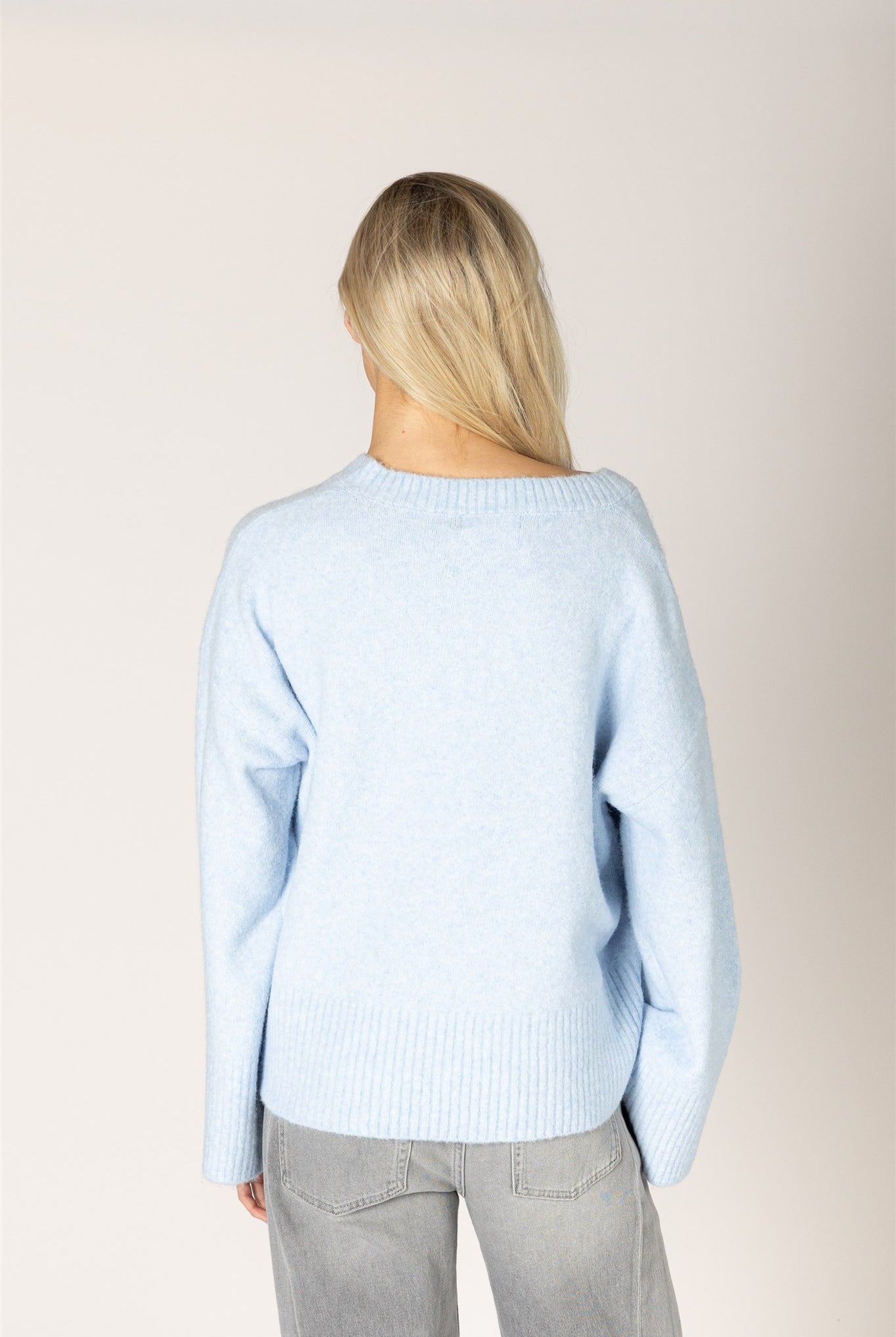 Breeze blue V-neck sweater in a lightweight knit, featuring a relaxed fit, long sleeves, and ribbed trim at the neckline, cuffs, and hem.