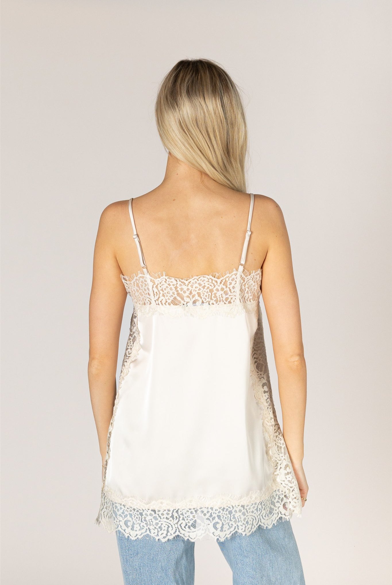 Ivory lace trim camisole top with delicate lace detailing at the neckline and hem.