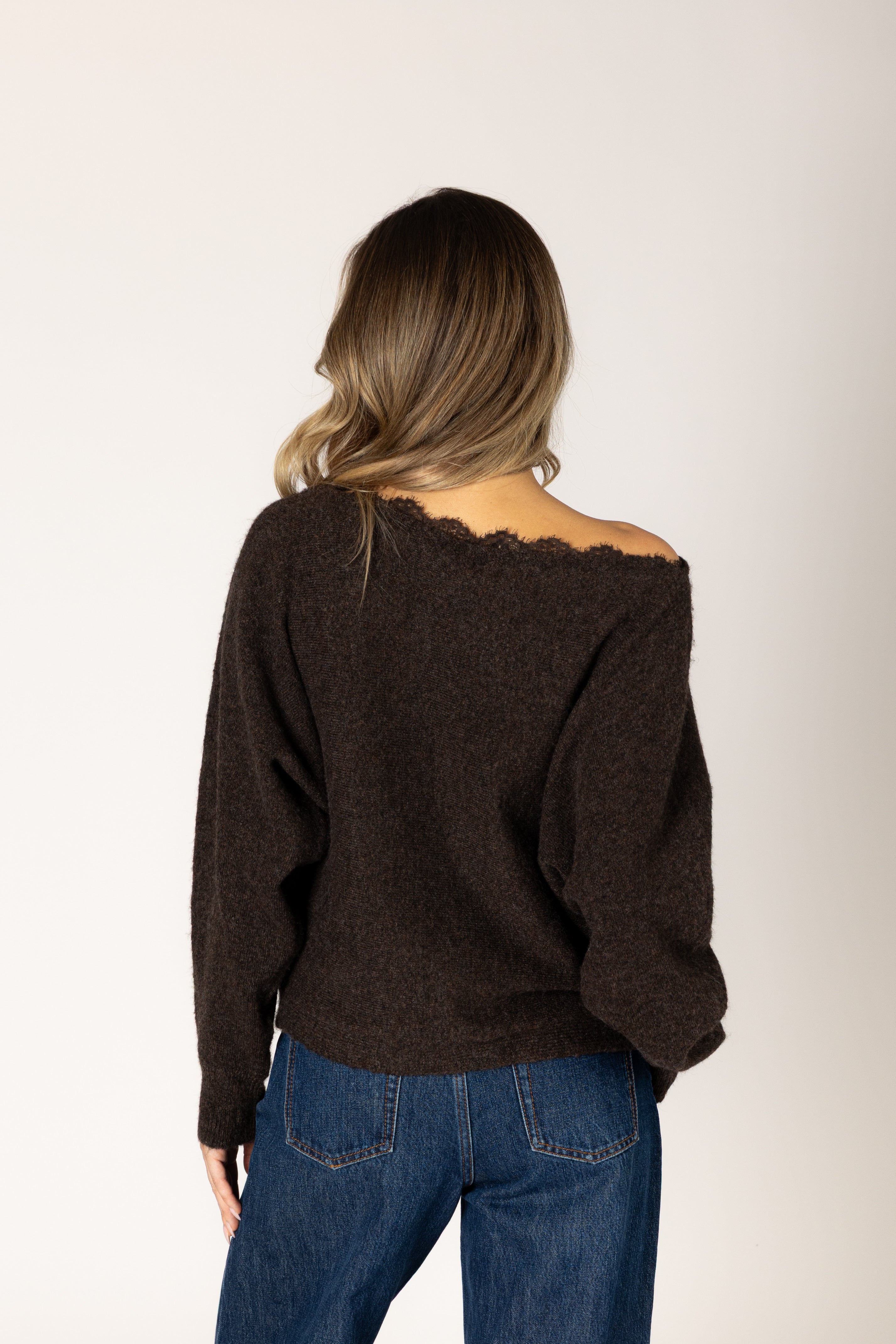 Knit lace sweater featuring an off-the-shoulder neckline, relaxed silhouette, and textured lace design in a neutral tone.