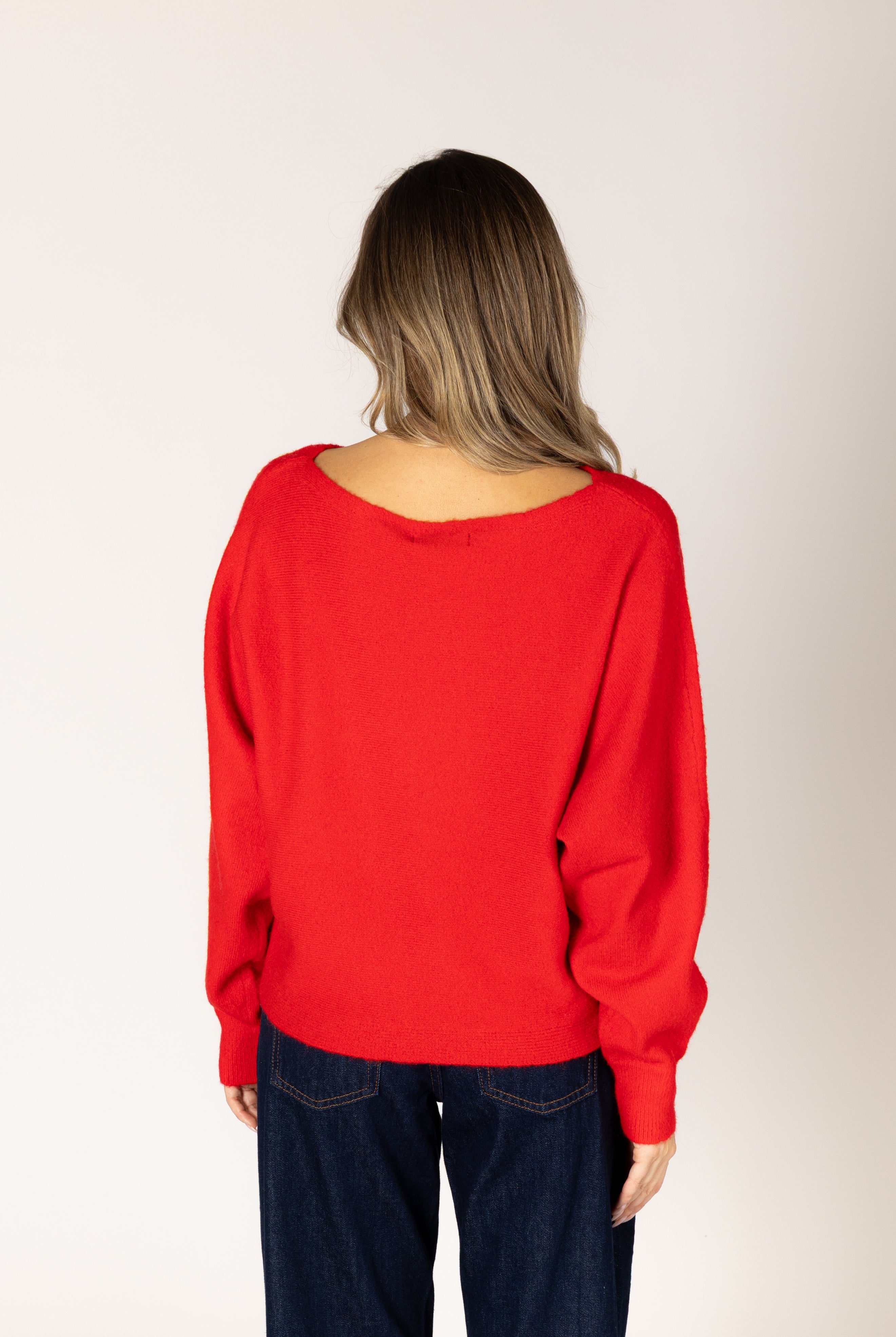 Off-the-shoulder knit sweater in a neutral tone, featuring a relaxed silhouette and wide neckline for an elegant, effortless look.
