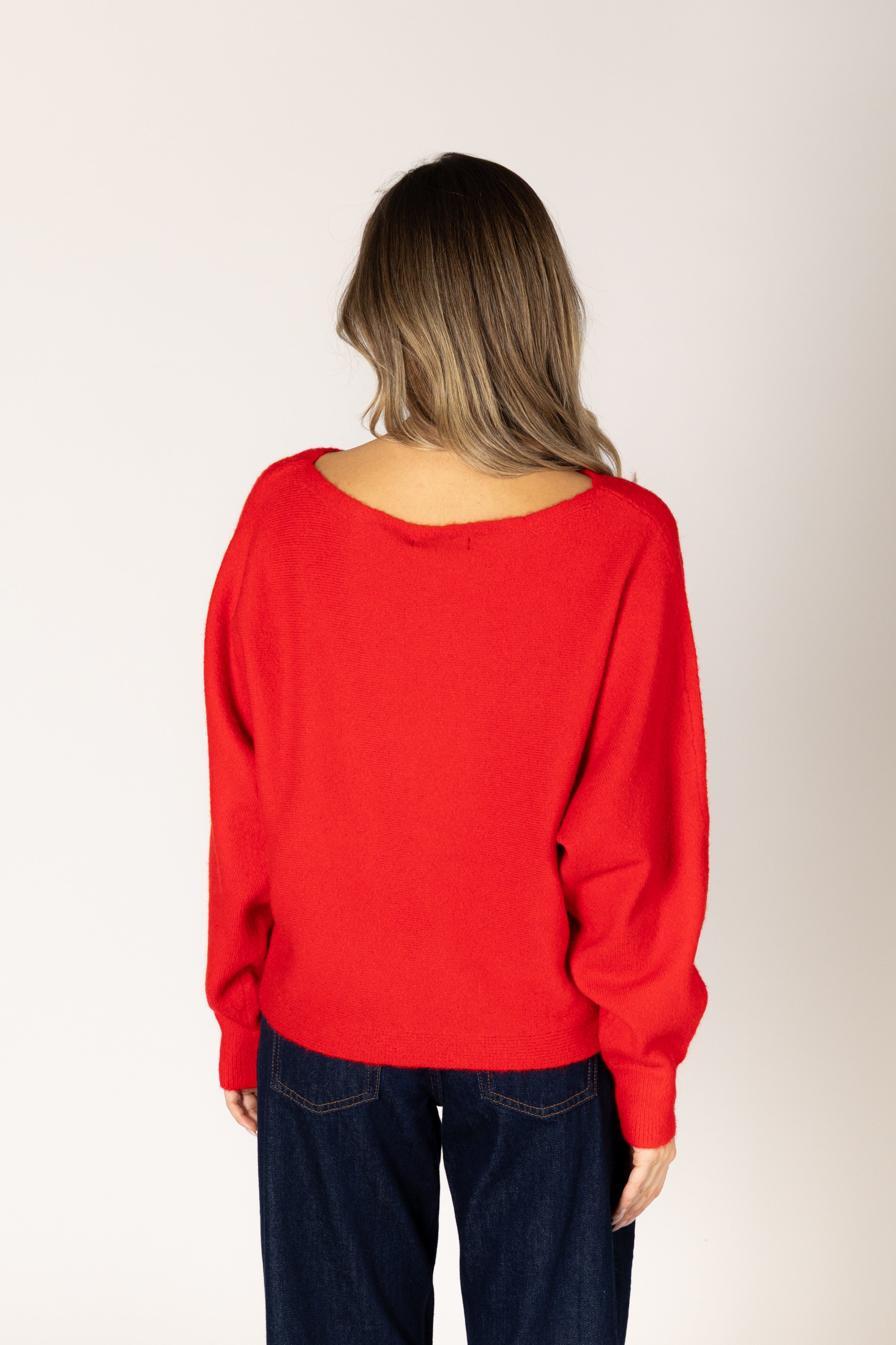 Off-the-shoulder knit sweater in a neutral tone, featuring a relaxed silhouette and wide neckline for an elegant, effortless look.