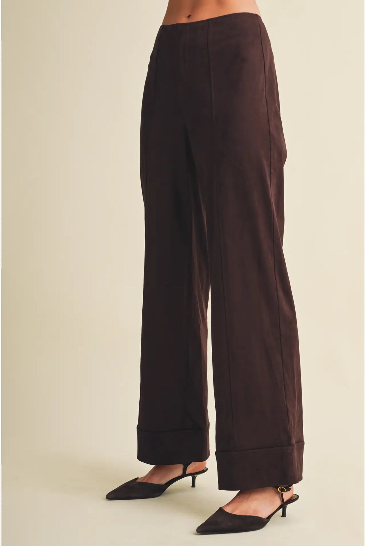 High-waisted faux suede pants with a slim wide-leg silhouette, pintuck detailing, full length, and wide cuffed hems. Model is 5'9" and wearing a size Small.