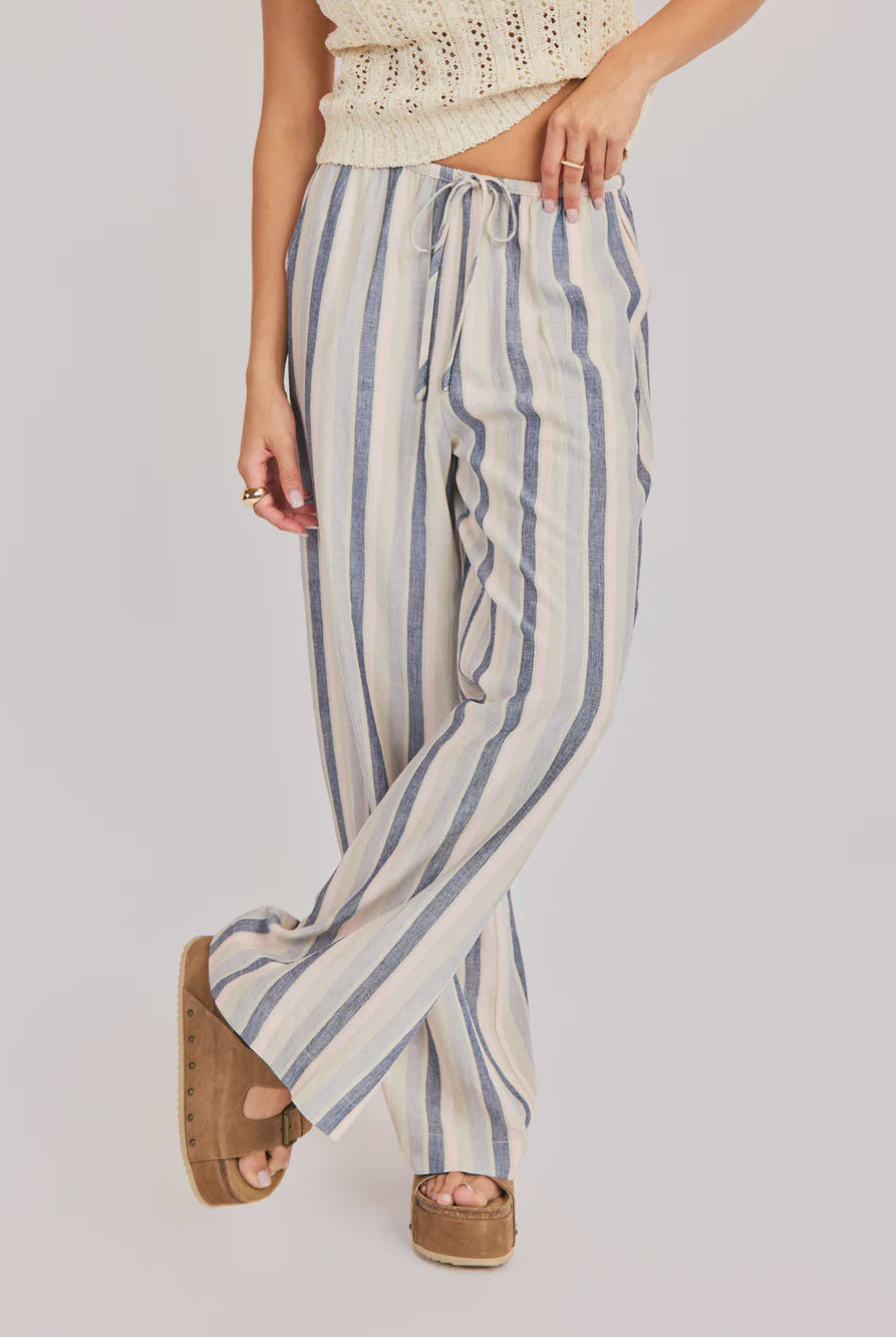 Woman wearing striped blue multi pants on a plain background