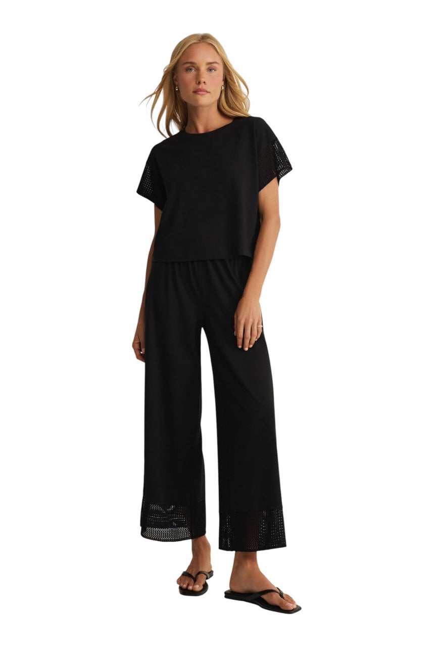 woman wearinng black straight leg ankle length pant with detailing at the bottom
