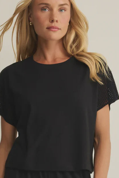 woman wearing black short sleeve top with crochet detailing on the sleeves