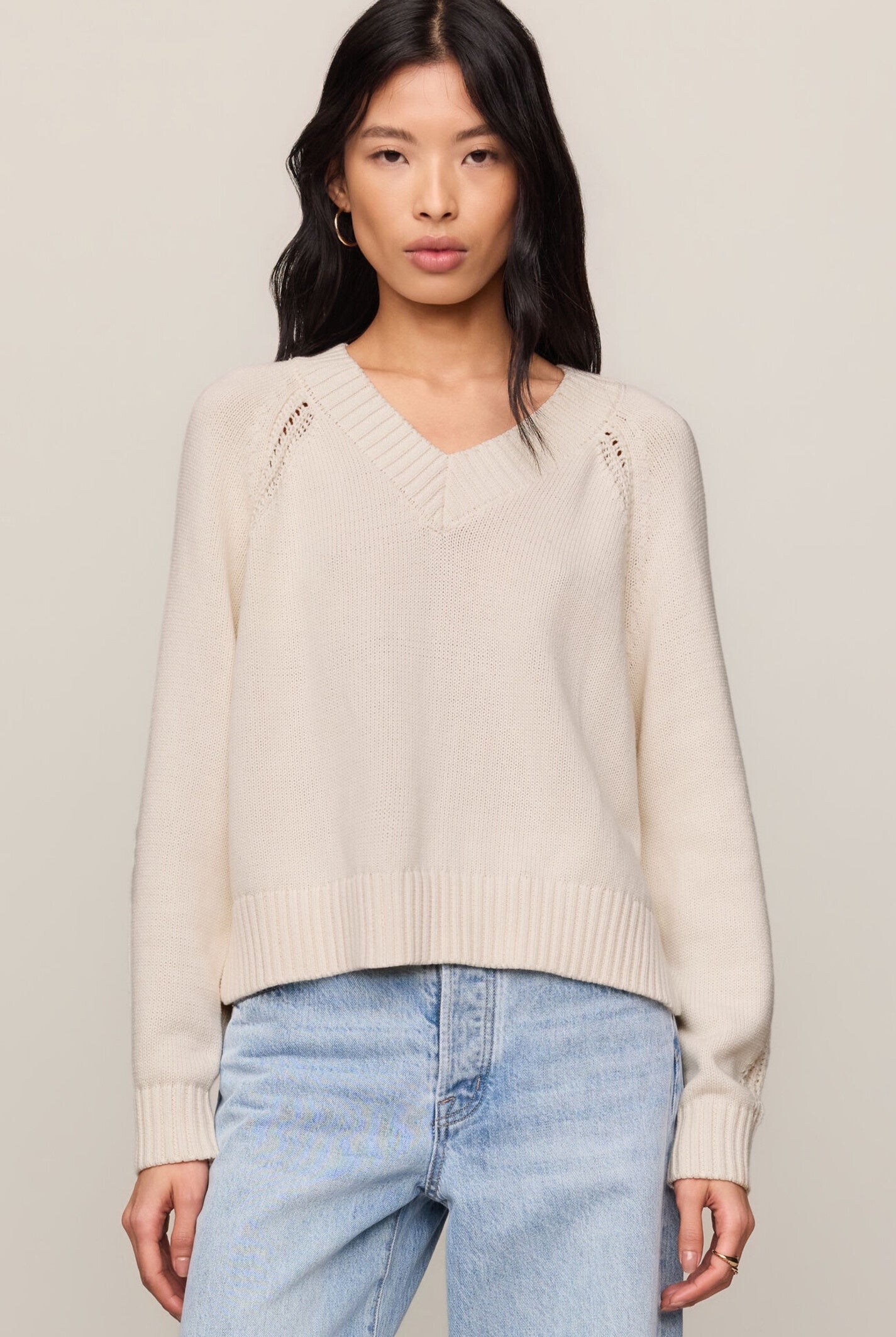 Model wearing the Z Supply Stratton V-Neck Sweater in Sandstone, featuring a V-neckline, long sleeves, and a soft cotton knit in a neutral beige hue.