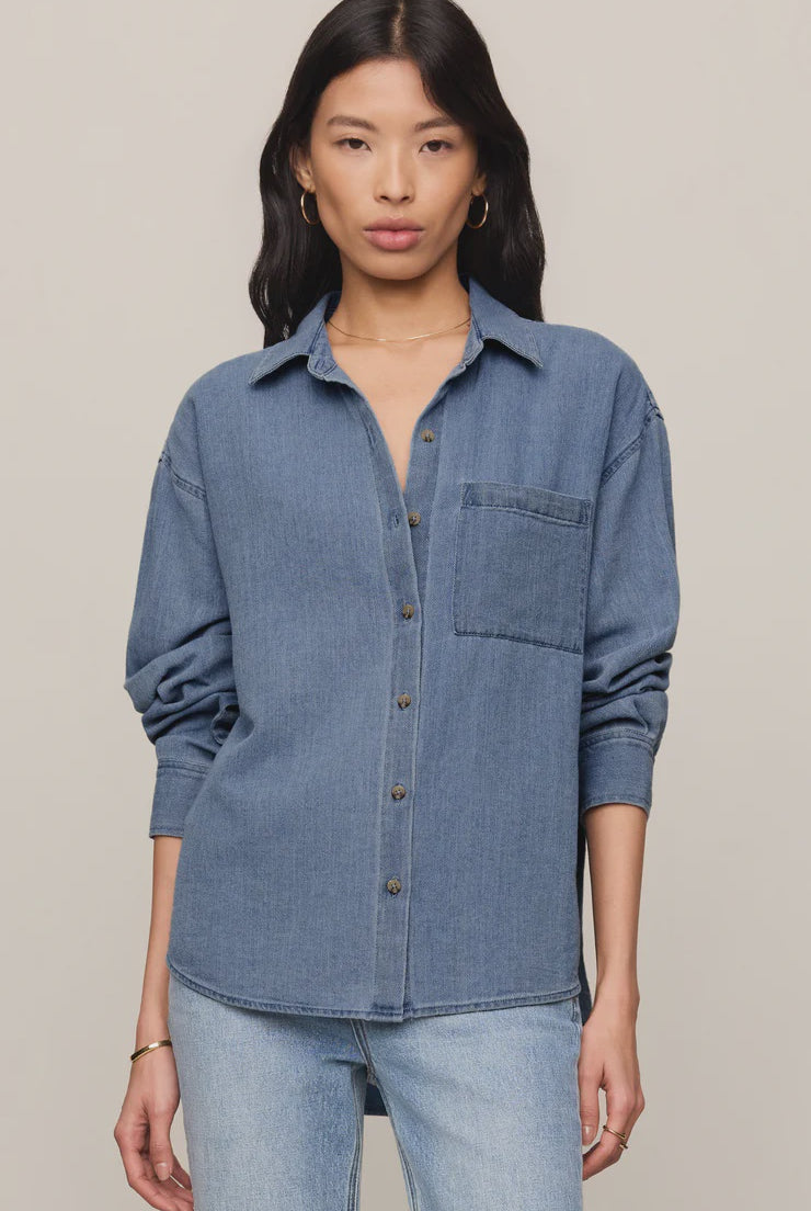 Relaxed-fit indigo cotton twill button-up shirt with a collared neckline, long sleeves, button-front closure, and a single chest pocket. Made from 100% cotton with a soft, drapey feel.