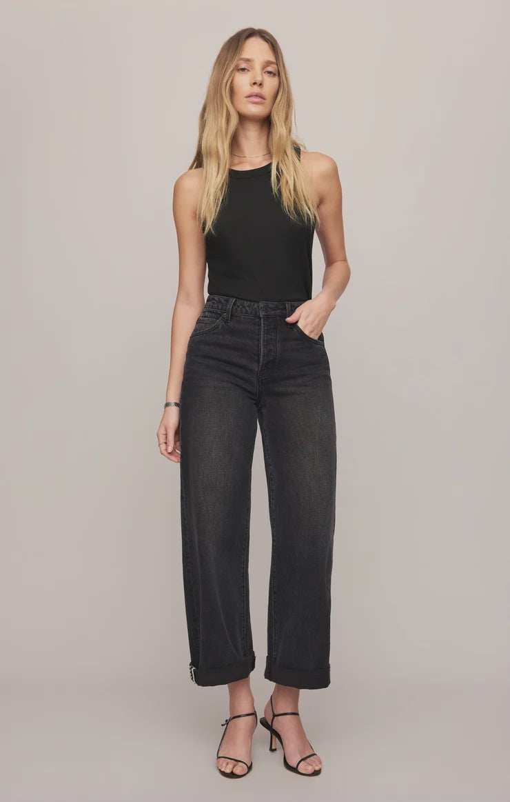 High-rise washed black jeans featuring a relaxed bowed-leg silhouette, full-length hem, and contrast whipstitch detailing inside the cuff.