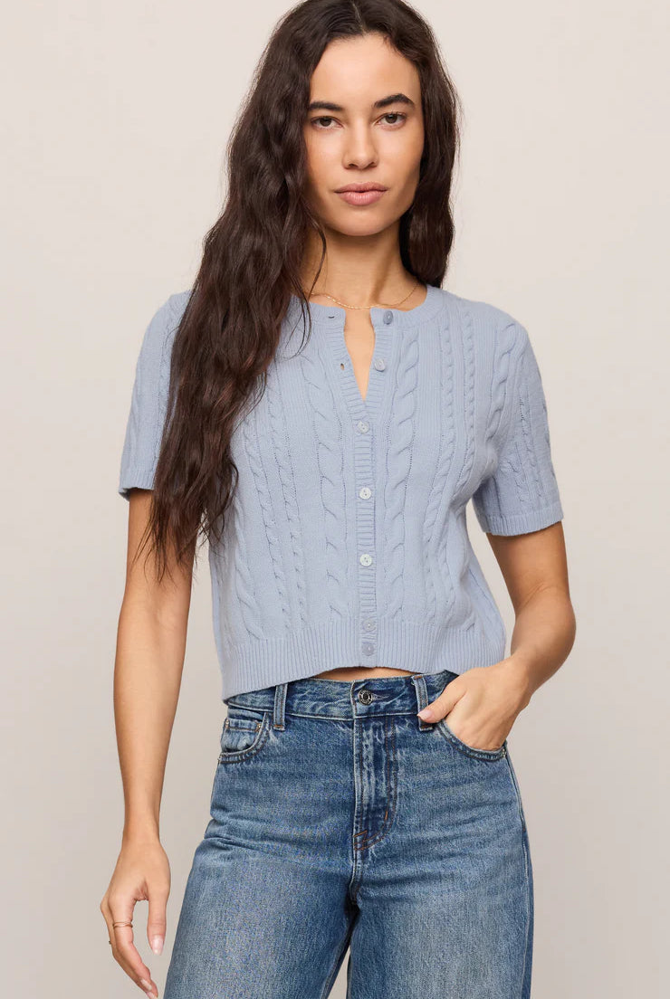 Model wearing a regular-fit cable knit cardigan with a crew neckline, short sleeves, and a button-front closure.