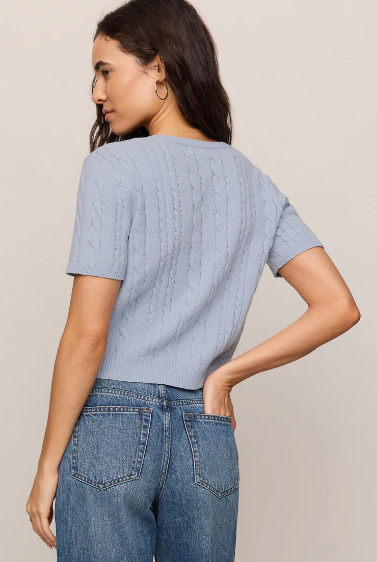 Model wearing a regular-fit cable knit cardigan with a crew neckline, short sleeves, and a button-front closure.