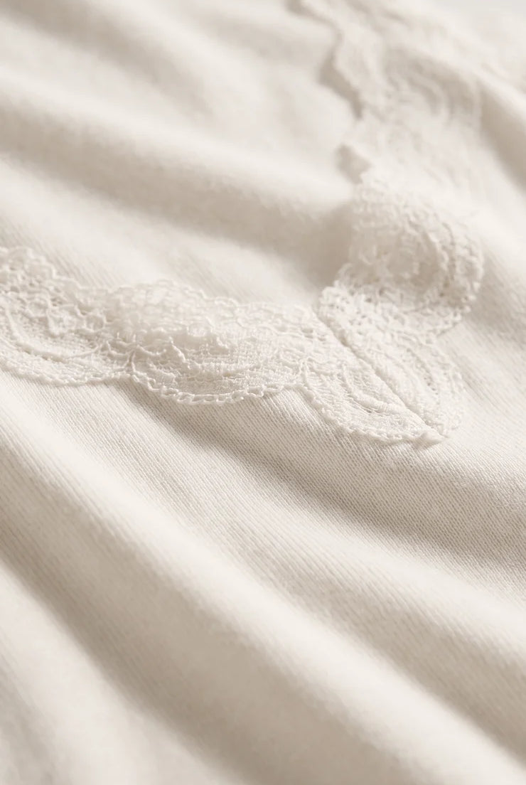 Fitted baby rib cotton tank with a lace-trimmed V-neckline and wide straps. A soft, feminine essential that's perfect for layering or wearing on its own.