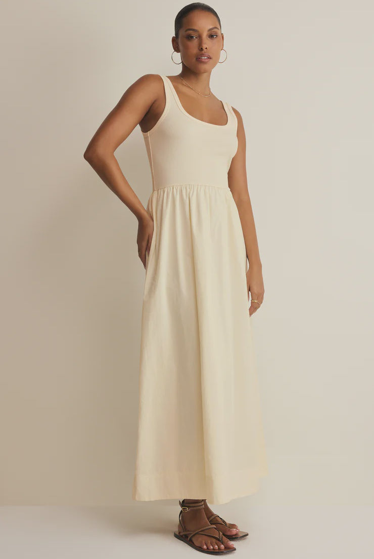 Woman wearing an off white sleeveless poplin dress against a plain background
