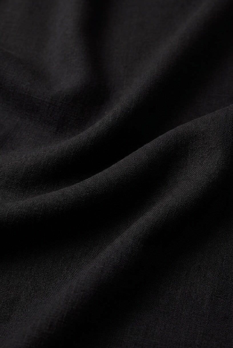 Close-up of the Z Supply Leyla Jumpsuit's black fabric, showing its soft, lightweight rayon-spandex blend with a smooth texture and fluid drape.
