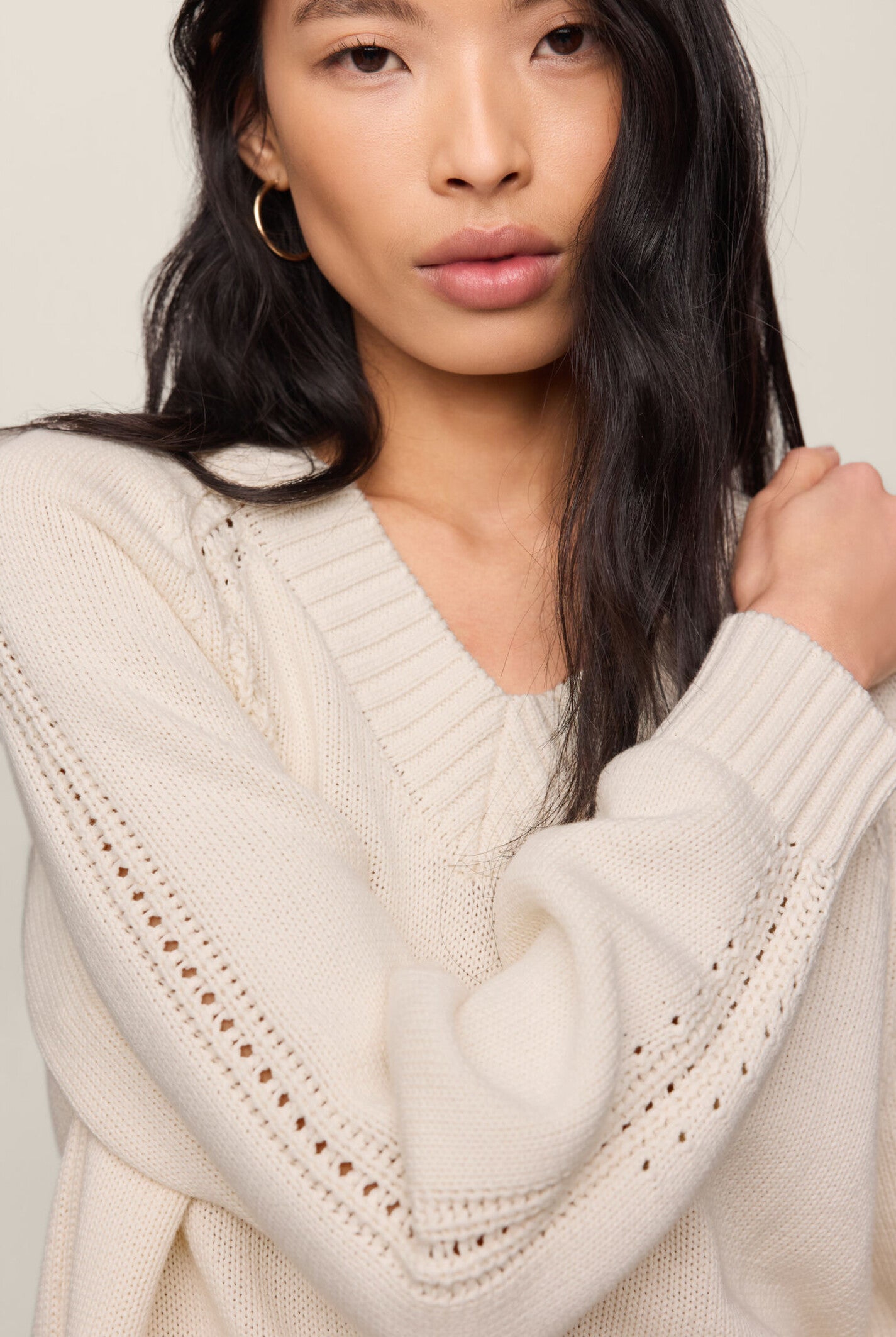 Model wearing the Z Supply Stratton V-Neck Sweater in Sandstone, featuring a V-neckline, long sleeves, and a soft cotton knit in a neutral beige hue.