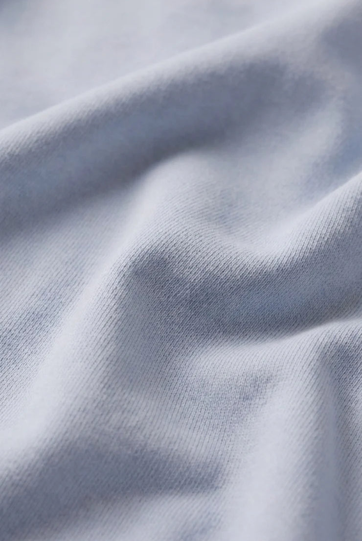 Close-up of the baby French terry fabric, showcasing its soft cotton-blend texture with a smooth exterior and plush looped interior for lightweight comfort.
